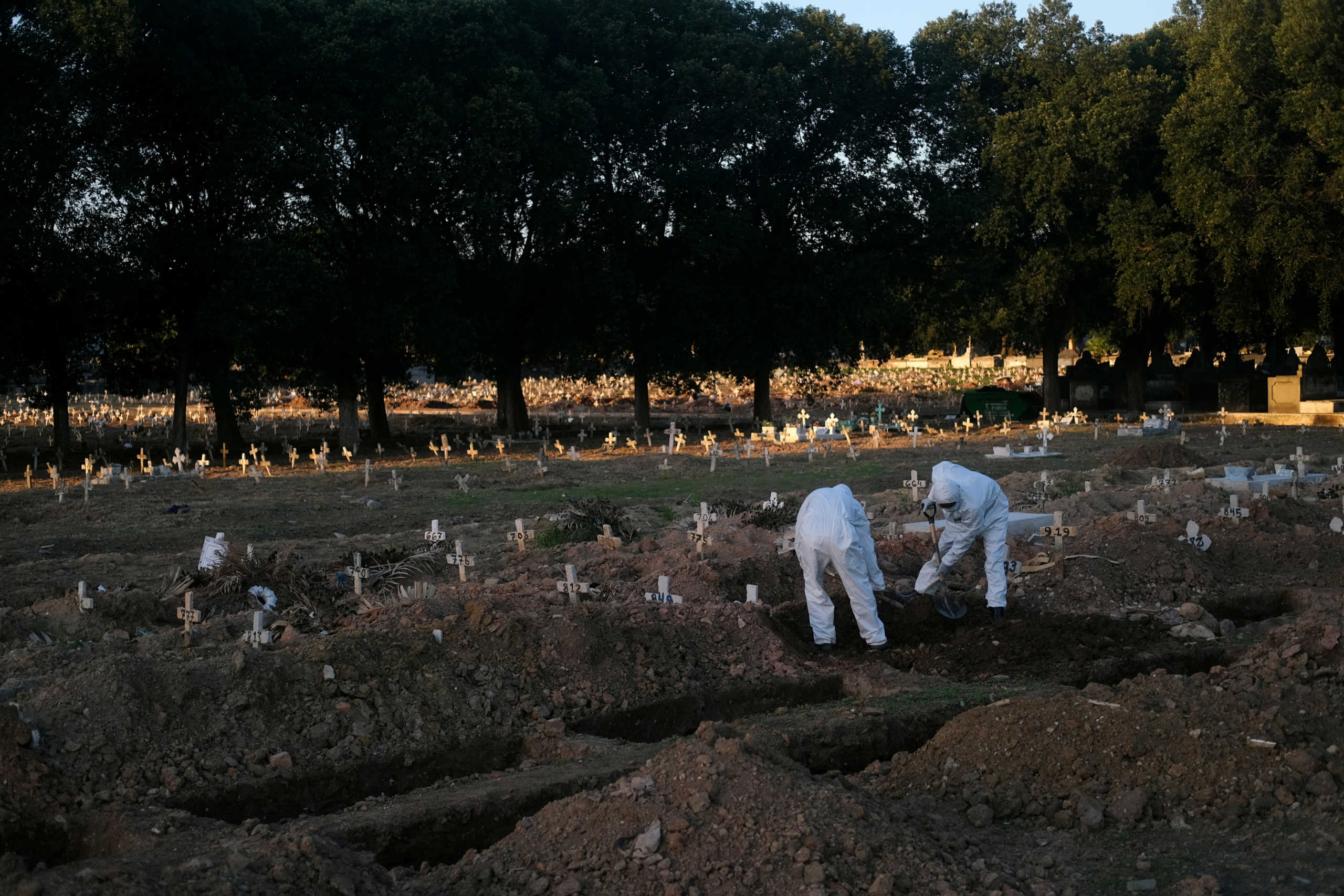 Gravediggers bury the body of a person who died from the coronavirus disease (COVID-19), in Sao Francisco Xavier cemetery, in Rio de Janeiro, Brazil, May 29, 2020. REUTERS