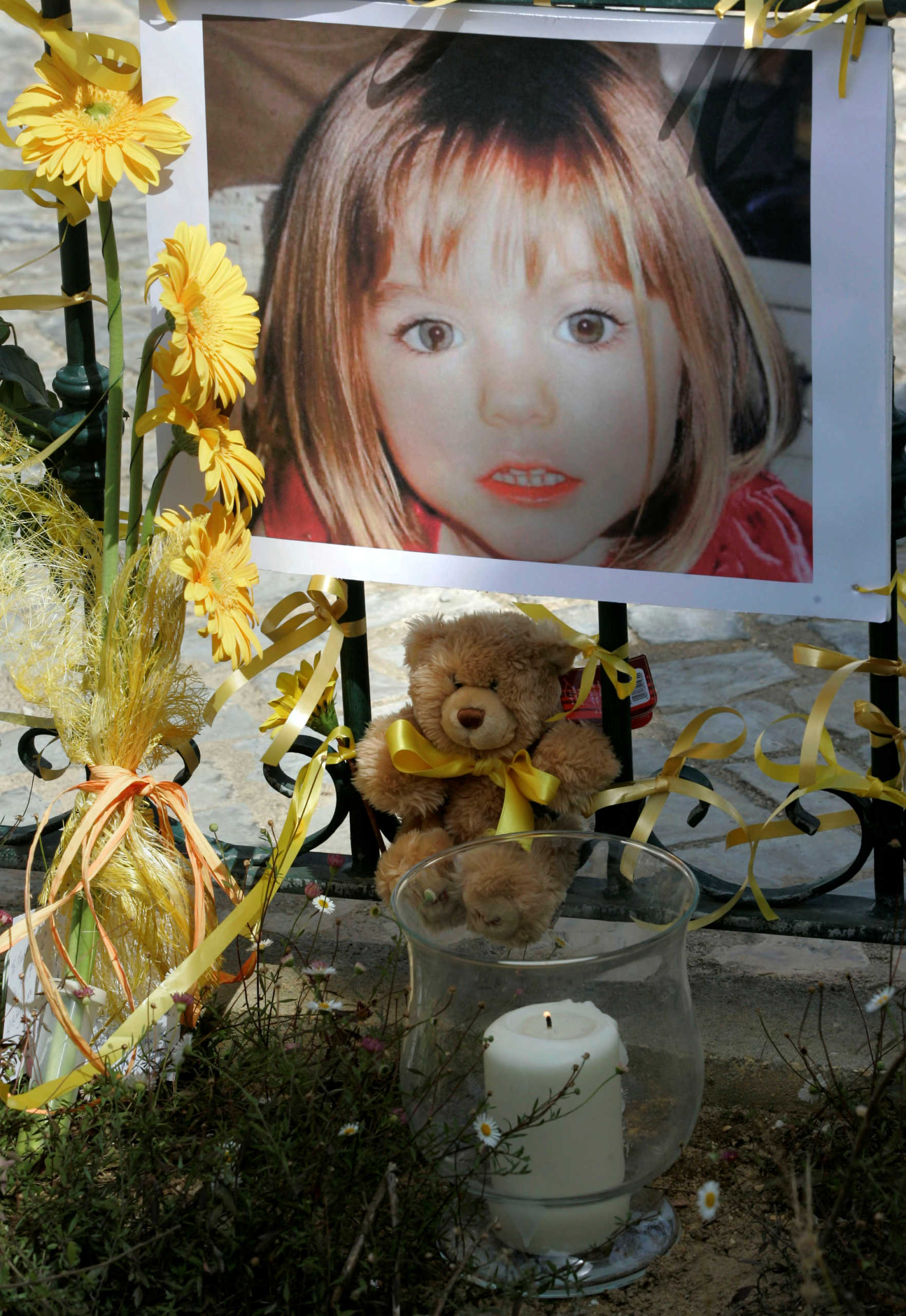 FILE PHOTO: Poster of the missing three-year-old British girl Madeleine McCann is surrounded by flowers and hope-bows in the Portuguese beach resort of Lagos May 12, 2007. REUTERS