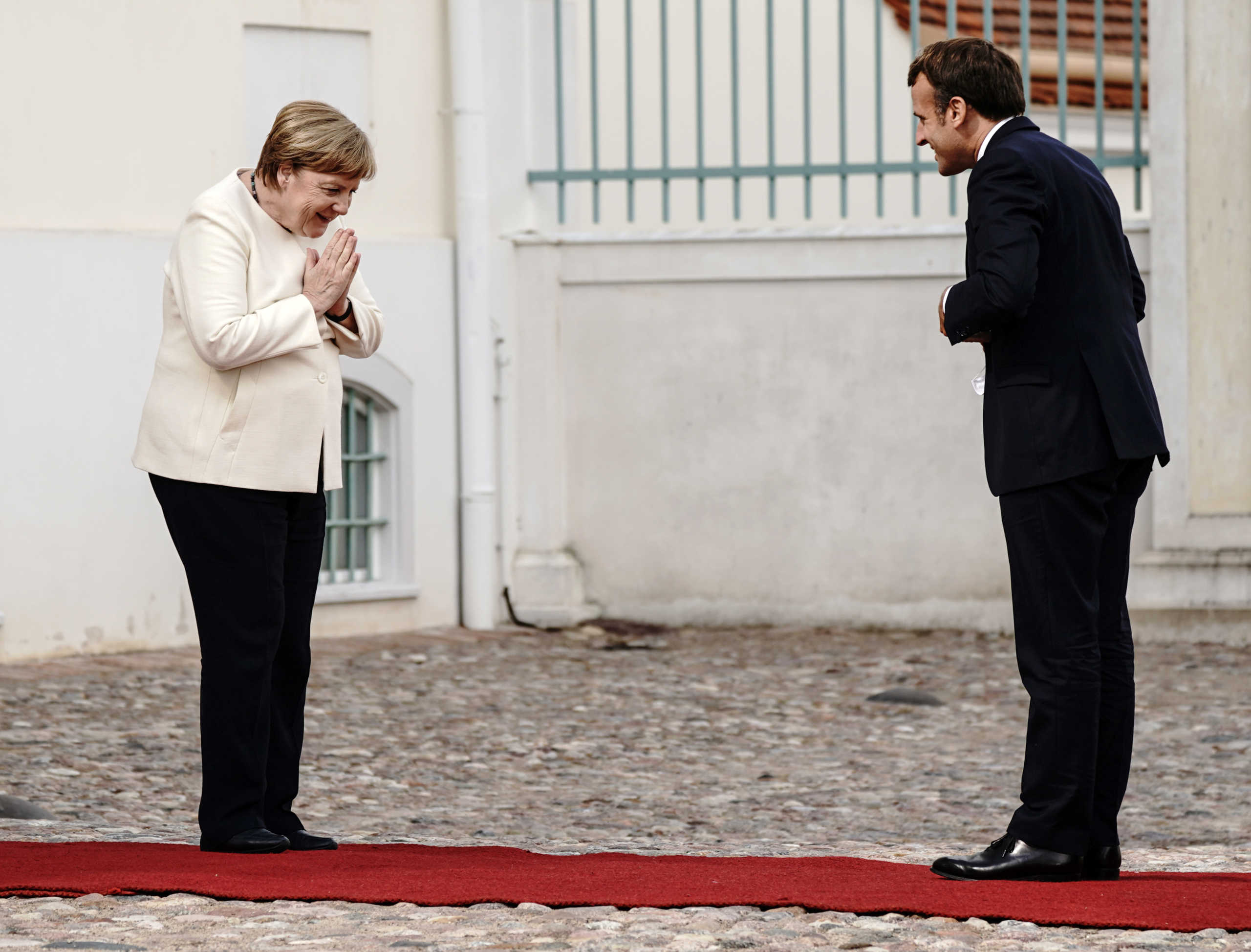 German Chancellor Angela Merkel and French President Emmanuel Macron greet each other before they meet at Meseberg Castle, the federal government's guest house, in Meseberg, Germany June 29, 2020. Kay Nietfeld
