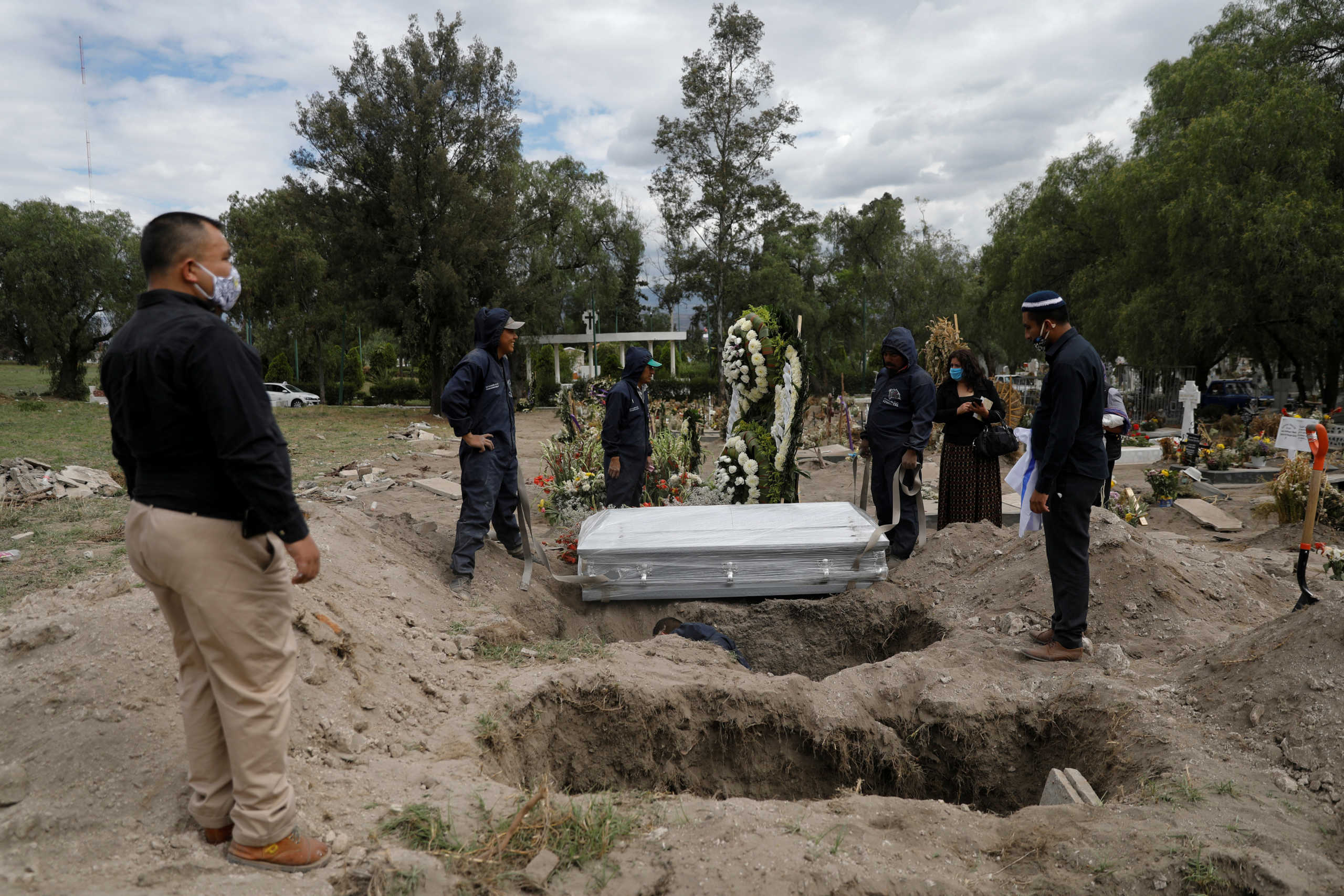 Family members say their last goodbyes to their relative who died of the coronavirus disease (COVID-19), at the San Lorenzo Tezonco cemetery in Mexico City, Mexico June 3, 2020. REUTERS