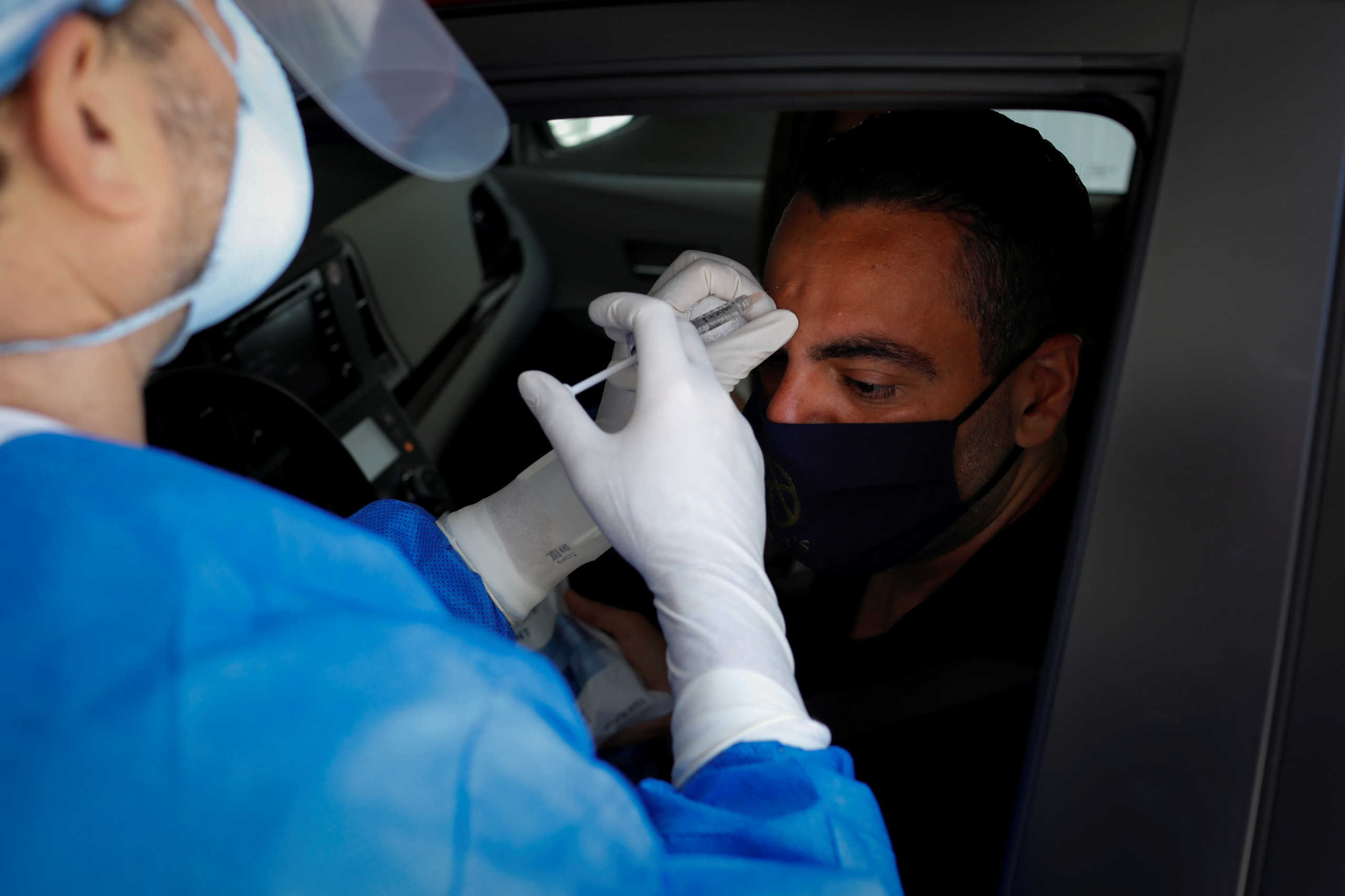 Michael Salzhauer, a plastic surgeon known as Dr. Miami, applies Botox to a patient while conducting drive-through Botox injections in the garage of his clinic, as Miami-Dade County eases some of the lockdown measures put in place during the coronavirus disease (COVID-19) outbreak, in Miami, Florida, U.S., May 31, 2020. Picture taken May 31, 2020. REUTERS