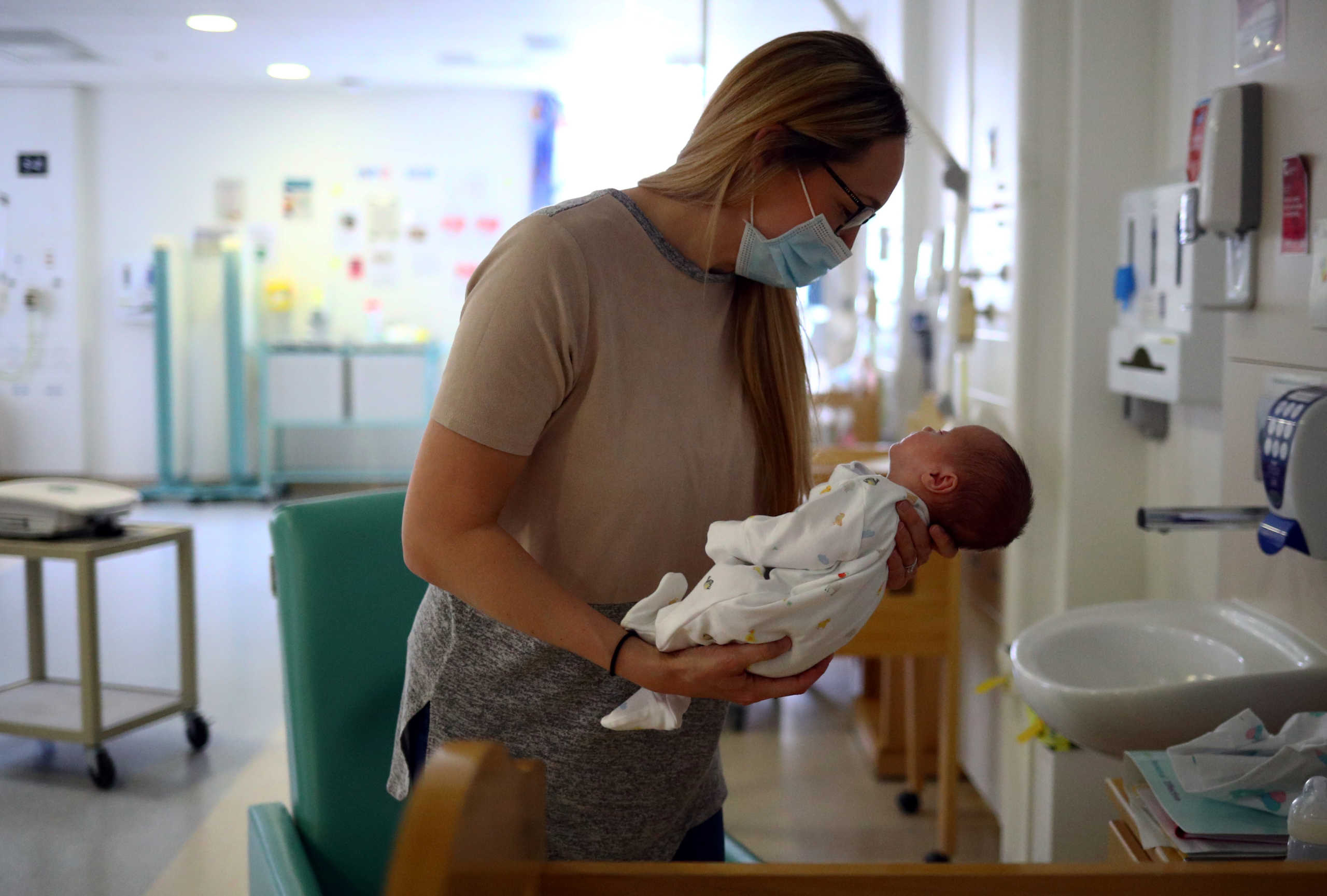 Kirsty Anderson holds her baby Theo, who was born prematurely and is now nine weeks old, as they wait for medical staff to discharge him from hospital in the Lancashire Women and Newborn Centre of Burnley General Hospital in East Lancashire, following the spread of the coronavirus disease (COVID-19) in Burnley, Britain, June 22, 2020. Picture taken June 22, 2020. REUTERS