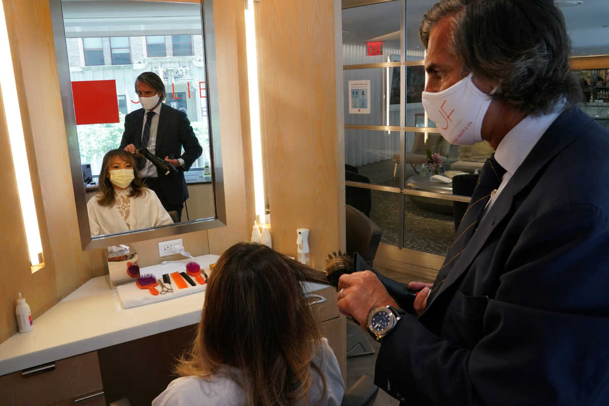 Julien Farel cuts a woman's hair in his salon, on the first day of the phase two re-opening of businesses following the outbreak of the coronavirus disease (COVID-19), in the Manhattan borough of New York City, New York, U.S., June 22, 2020. REUTERS