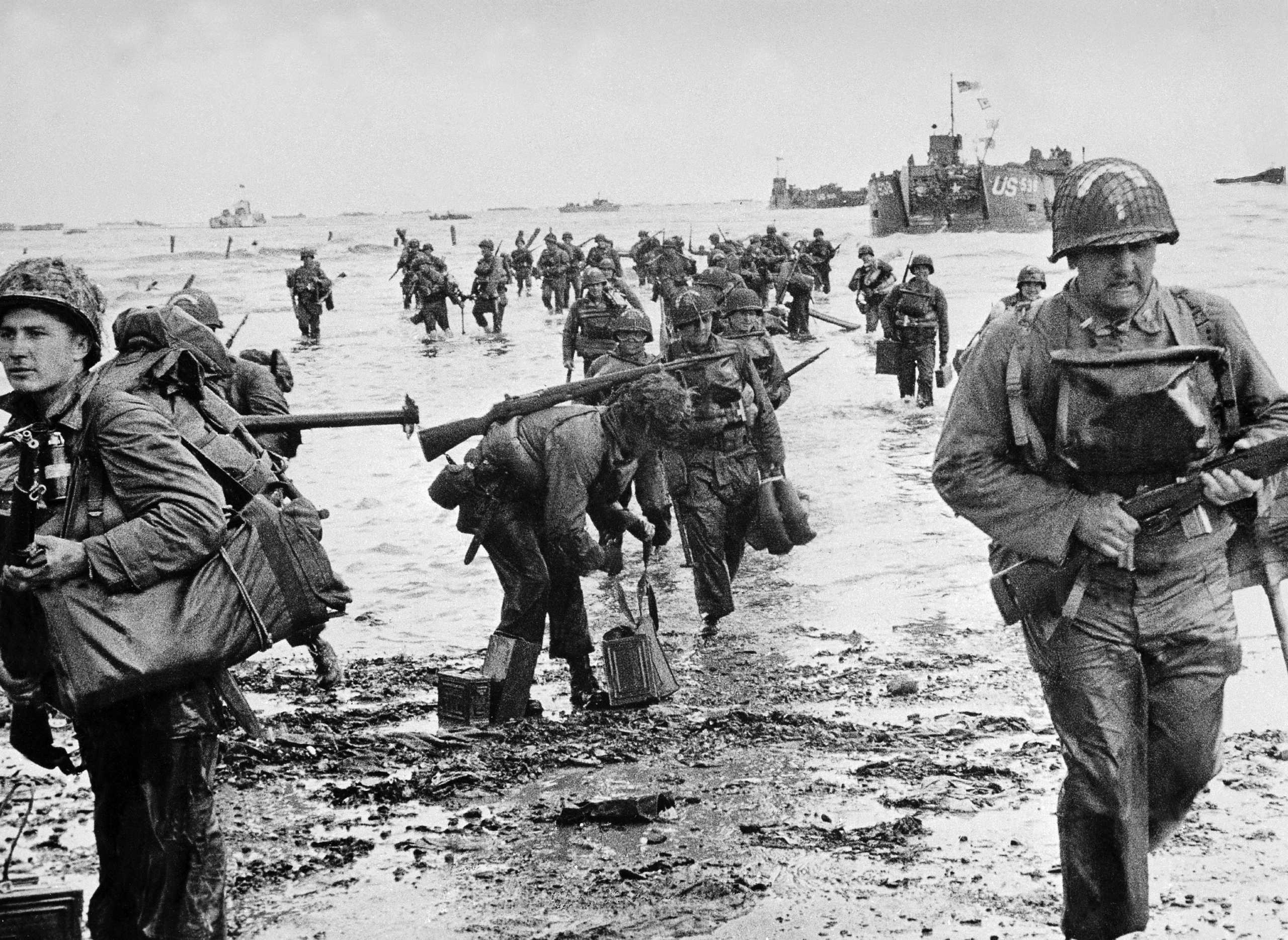 FRANCE - JUNE 06:  American soldiers, their feet in water, are landing on a Normandy beach. In the background are the American military ships which transported them.  (Photo by Keystone-France