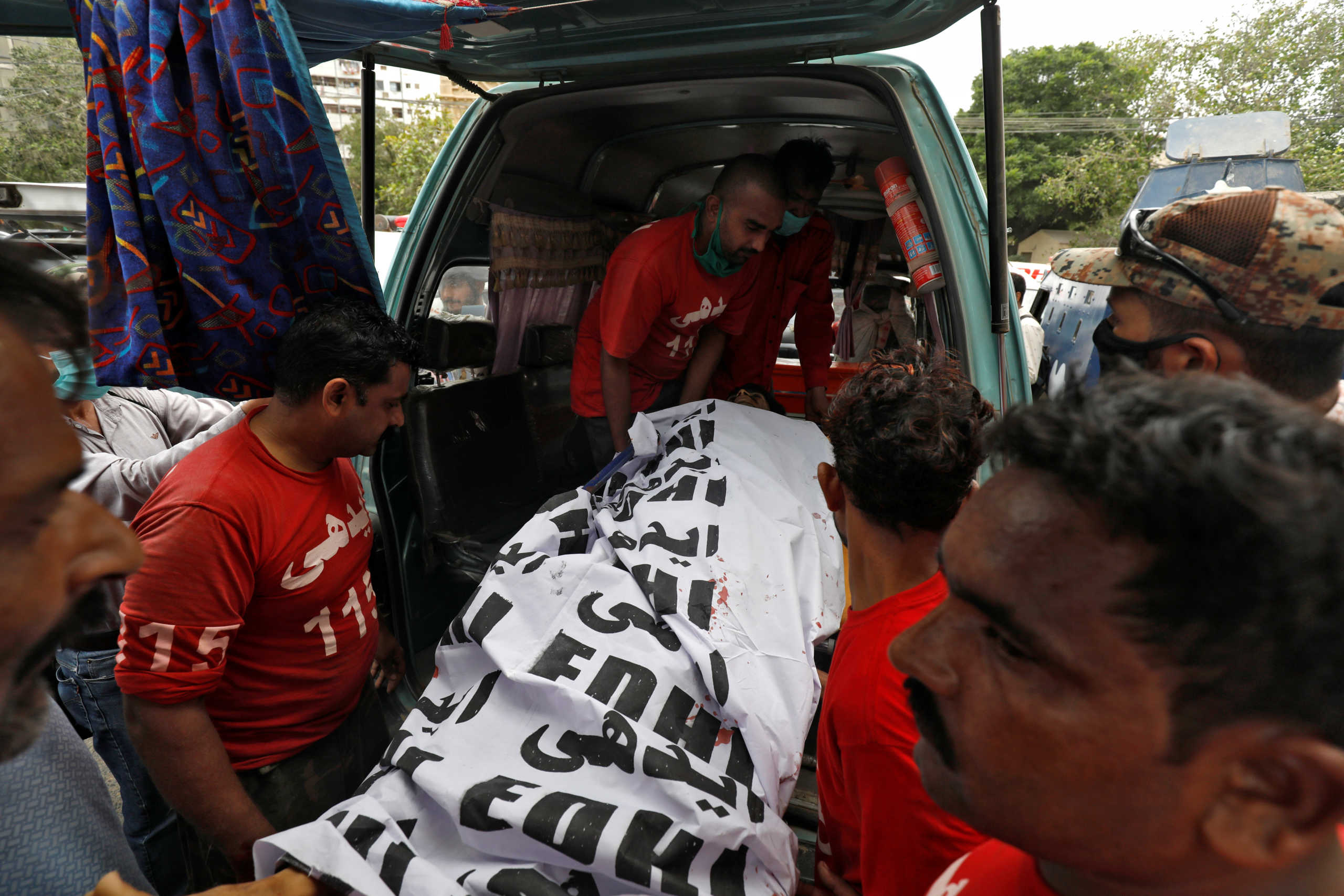 The covered body of a suspected attacker is removed at the site of an attack outside Pakistan Stock Exchange in Karachi June 29, 2020. REUTERS