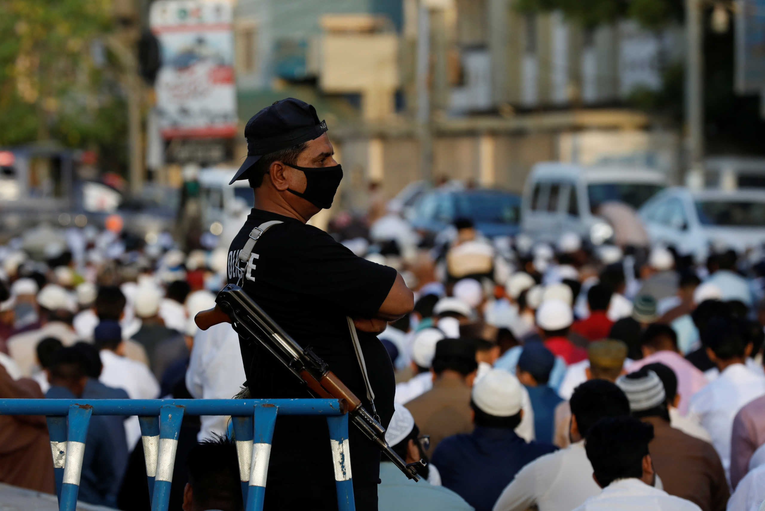 A police officer wearing a protective mask stands guard as Muslims celebrate Eid al-Fitr prayers to mark the end of the holy fasting month of Ramadan, amid the coronavirus disease (COVID-19) outbreak in Karachi, Pakistan May 24, 2020. REUTERS