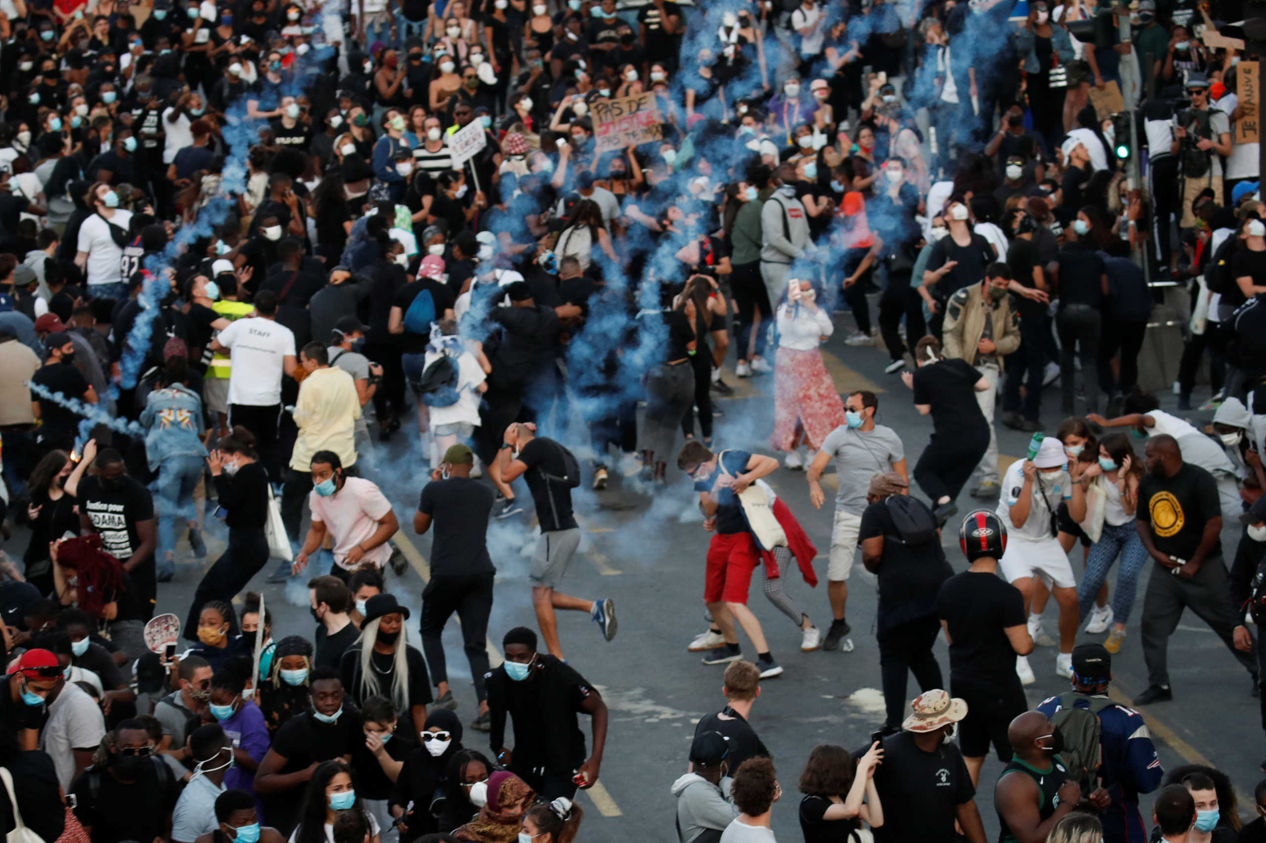 People run from tear gas as they attend a banned demonstration planned in memory of Adama Traore, a 24-year old black Frenchman who died in a 2016 police operation which some have likened to the death of George Floyd in the United States, in front of courthouse in Paris, France June 2, 2020. REUTERS