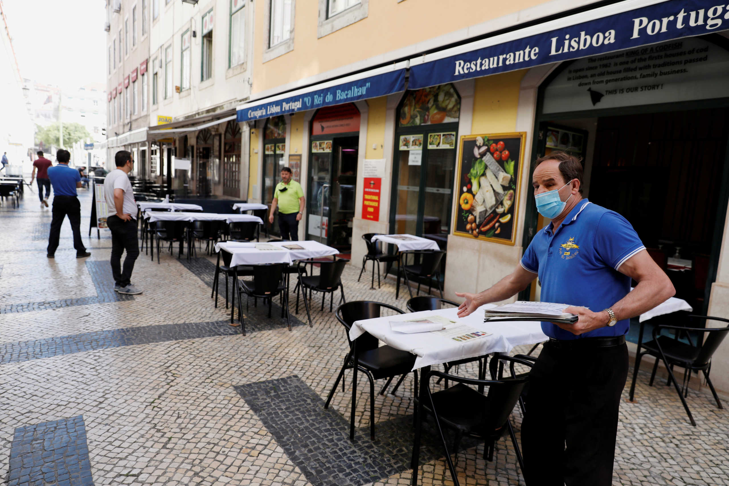 FILE PHOTO: A waiter waits for customers at a restaurant, amid the coronavirus disease (COVID-19) outbreak, in downtown Lisbon, Portugal May 25, 2020. REUTERS