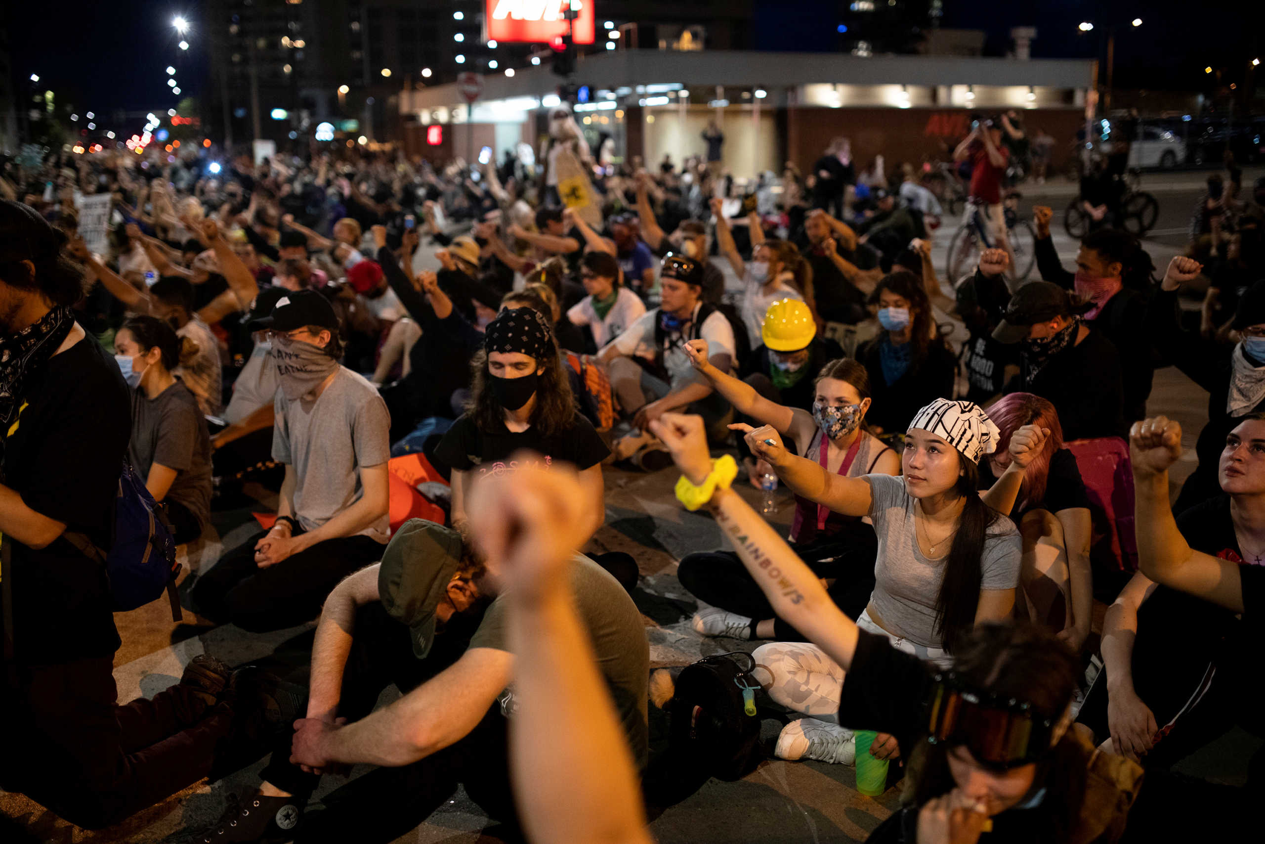 Demonstrators raise their fists as they sit in silence for nine minutes in a peaceful protest against the death in Minneapolis police custody of George Floyd, at 19th and Broadway in Denver, Colorado, U.S., June 1, 2020. Picture taken  June 1, 2020. REUTERS