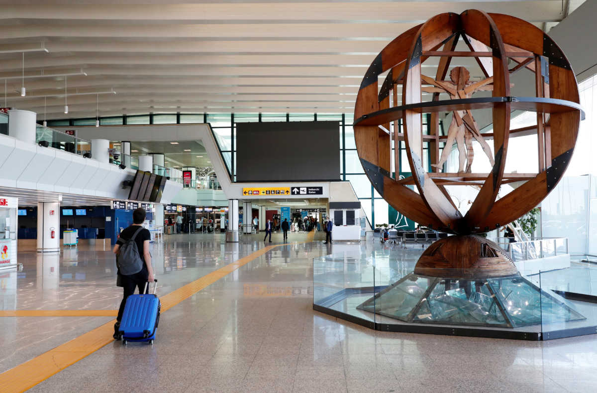 A passenger pushes his luggage at the Fiumicino airport, after Italy begun a gradual end to a nationwide lockdown due to the coronavirus disease (COVID-19), in Rome, Italy May 6, 2020. REUTERS