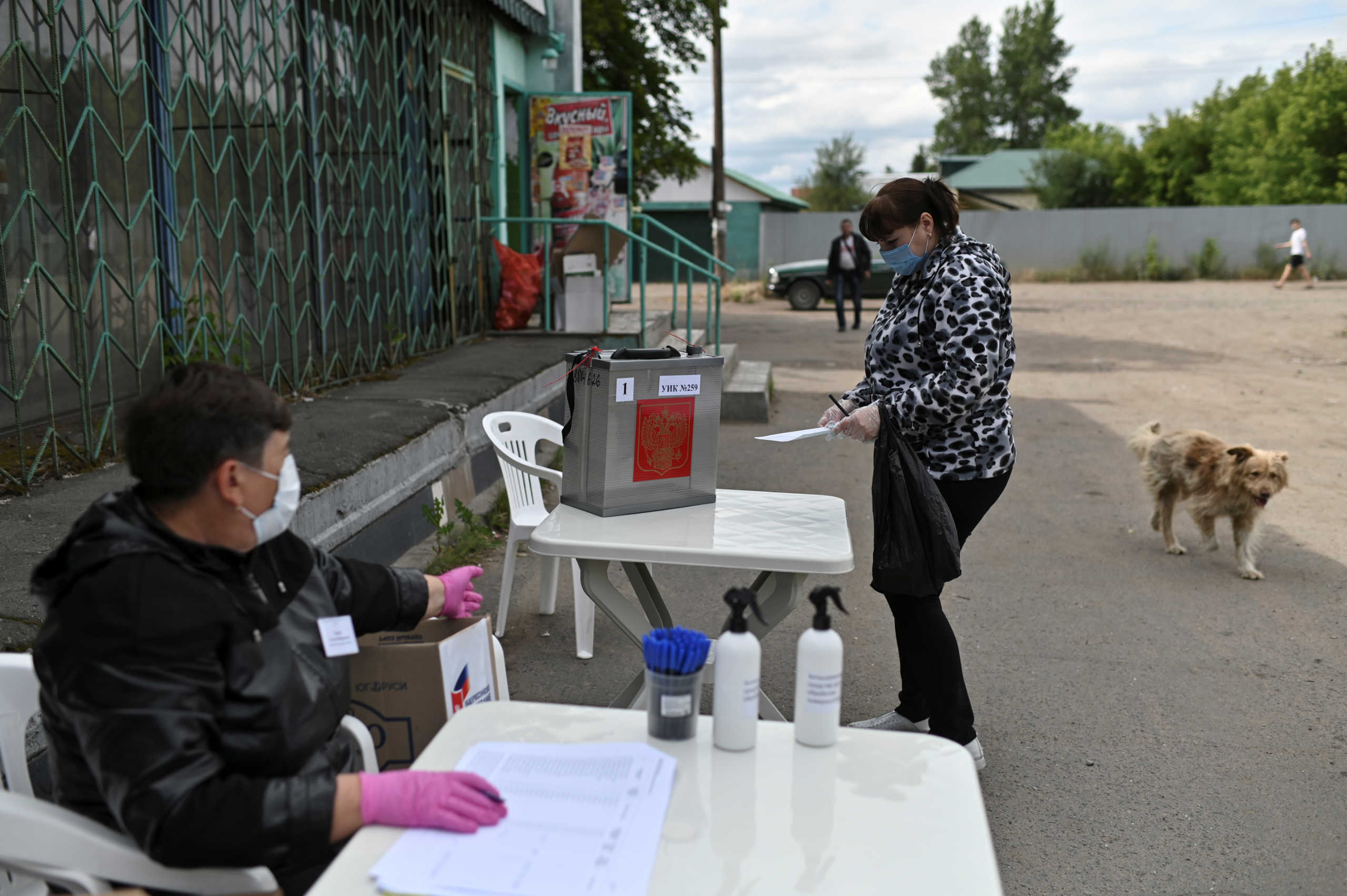 A member of a local electoral commission wearing a protective face mask, used as a preventive measure against the spread of the coronavirus disease (COVID-19), gives instructions at a mobile polling station during a seven-day nationwide vote on constitutional reforms in the village of Nikolayevka in Omsk Region, Russia June 26, 2020. REUTERS