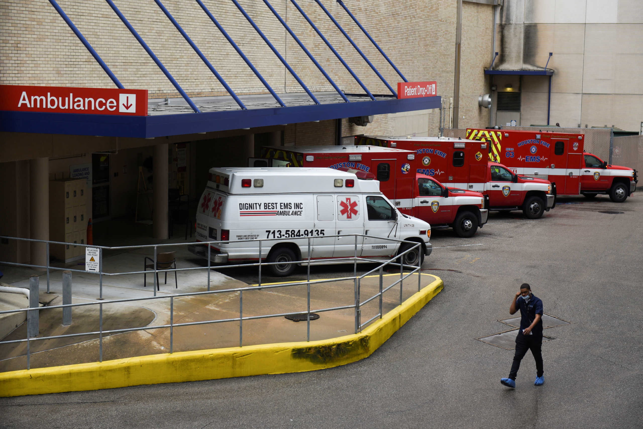 FILE PHOTO: A medical worker walks past a row of ambulances parked outside of Houston Methodist Hospital as storm clouds gather over the Texas Medical Center, amid the global outbreak of the coronavirus disease (COVID-19). in Houston, Texas, U.S., June 22, 2020.  REUTERS