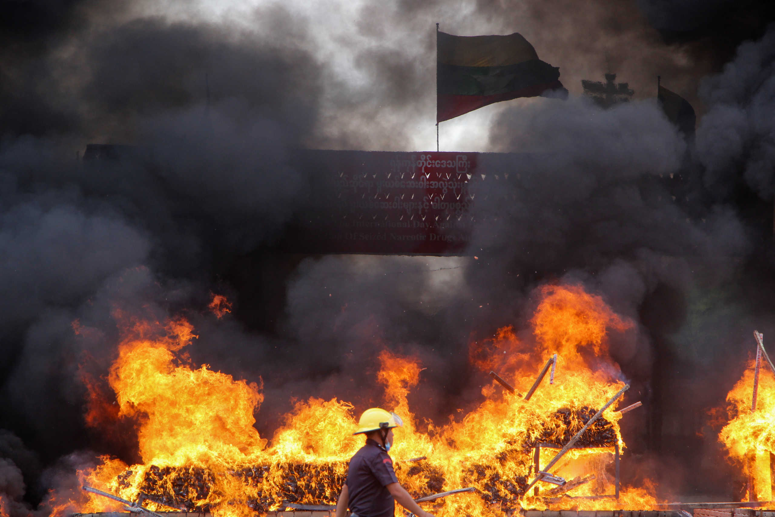 A firefighter walks by the burning drugs during a destruction ceremony to mark International Day against Drug Abuse and Illicit Trafficking in Yangon, Myanmar, June 26, 2020. REUTERS