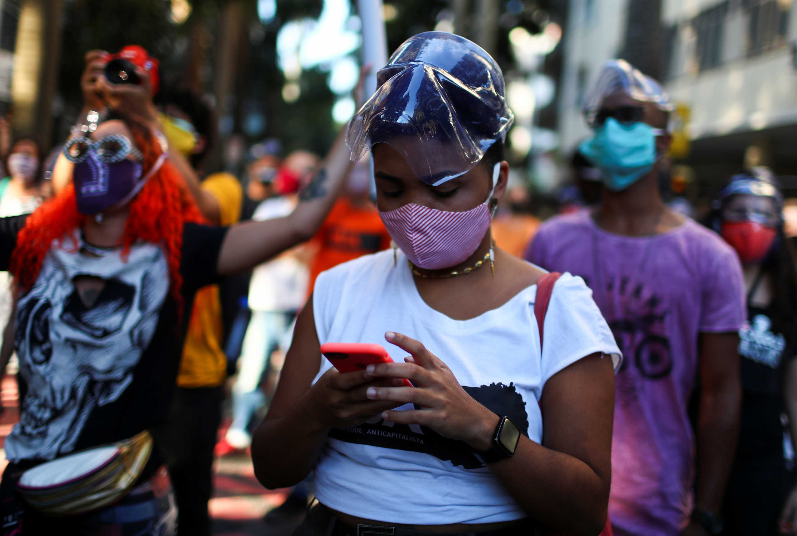 A woman wearing a face mask takes part in a protest against police violence during operations in slums against drug gangs and racism in Brazil, in front of the Guanabara Palace in Rio de Janeiro, Brazil, May 31, 2020. REUTERS