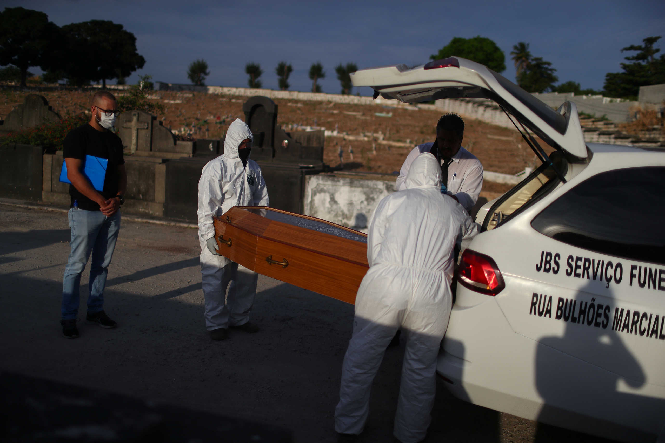 Carlos Alexandre looks at his father coffin, 76- year-old Jose Herminio de Farias, who died from the coronavirus disease (COVID-19) at the Sao Francisco Xavier cemetery in Rio de Janeiro, Brazil June 6, 2020.  REUTERS
