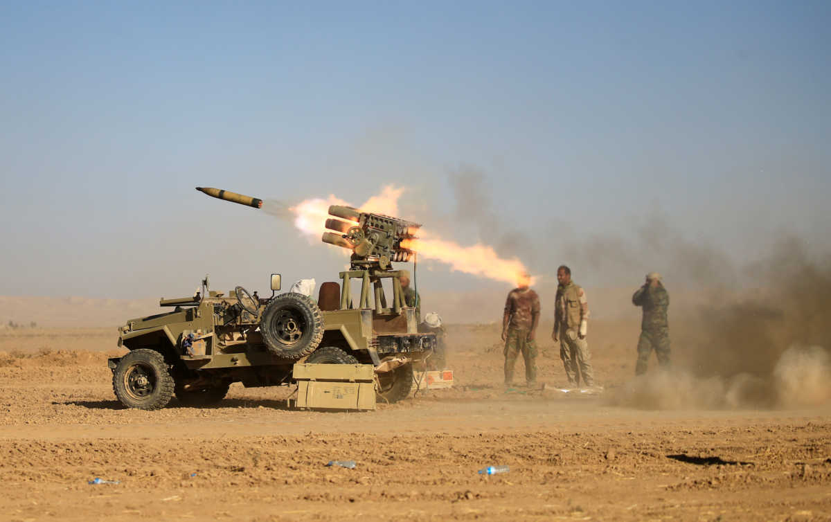 FILE PHOTO: Shi'ite fighters fire a rocket towards Islamic State militants during a battle with Islamic State militants at the airport of Tal Afar, west of Mosul, Iraq, November 18, 2016. REUTERS