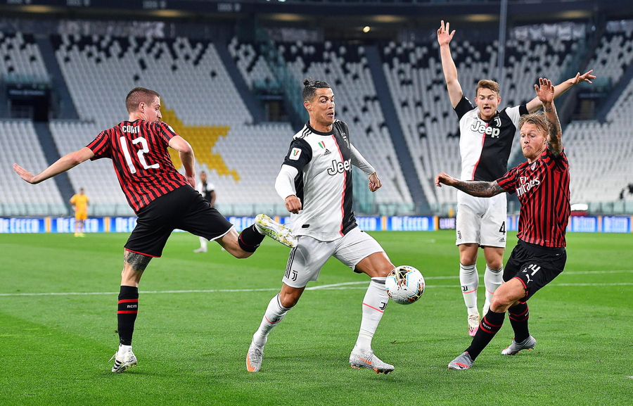 epaselect epa08481665 Juventus' Cristiano Ronaldo (C) in action against Milan's Andrea Conti (L) during the Coppa Italia semi final, second leg soccer match between Juventus FC and AC Milan in Turin, Italy, 12 June 2020.  EPA