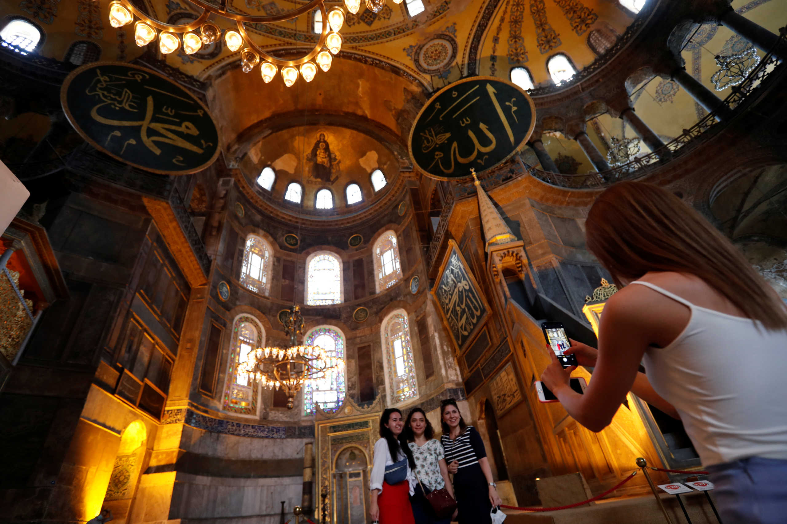 Visitors pose for a picture at Hagia Sophia or Ayasofya, a UNESCO World Heritage Site, which was a Byzantine cathedral before being converted into a mosque and currently a museum, in Istanbul, Turkey, July 10, 2020. REUTERS