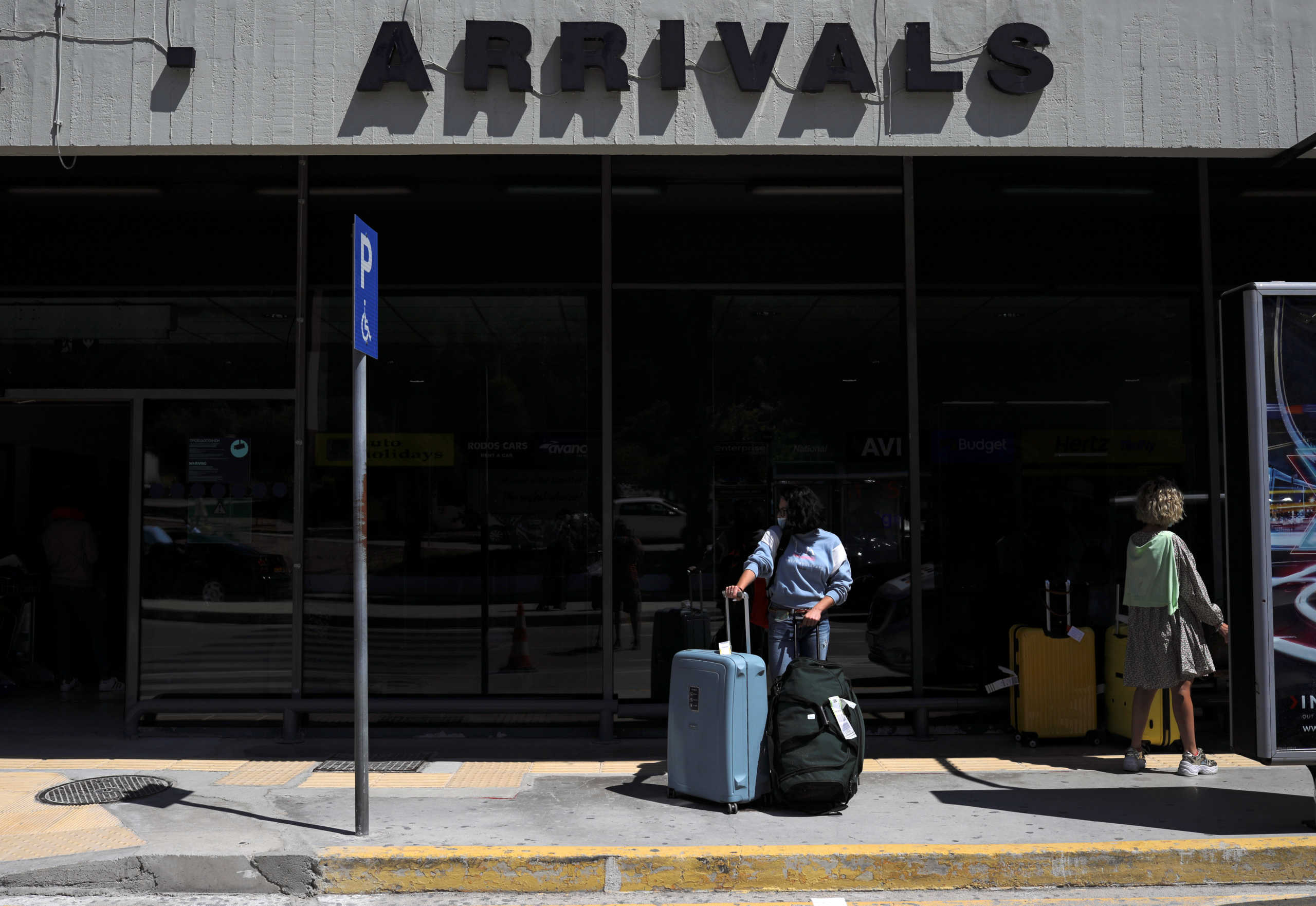 A passenger from Germany stands outside the Rhodes International Airport after the lifting of travel restrictions following the coronavirus disease (COVID-19) outbreak, on the island of Rhodes, Greece July 1, 2020. REUTERS