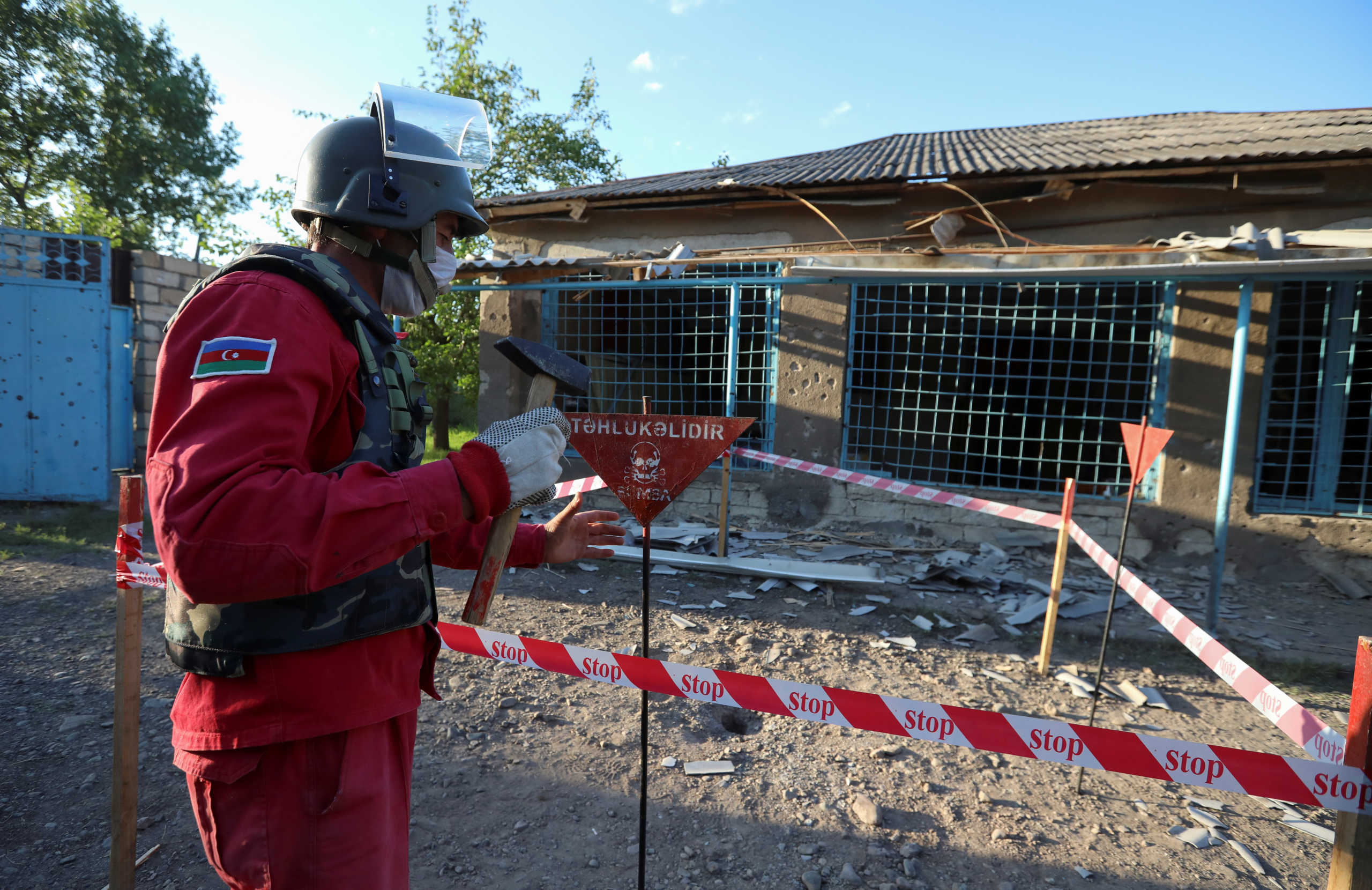 A sapper works at a yard with unexploded shell next to a house, which locals said was damaged during a recent shelling by Armenia's forces, in armed clashes on the border between Azerbaijan and Armenia, in the village of Agdam, Azerbaijan July 15, 2020.  REUTERS