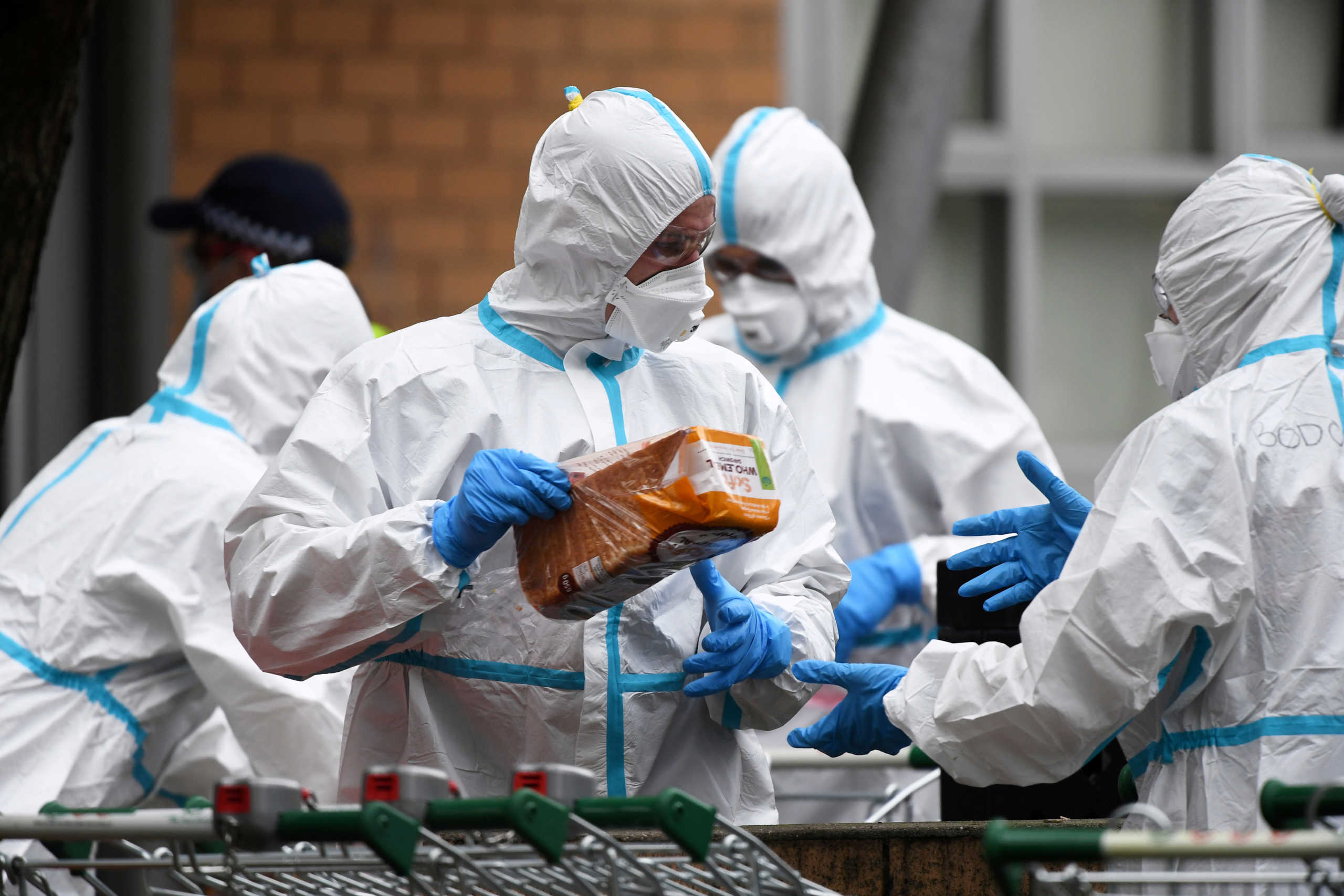 Firefighters dressed in personal protective equipment prepare to distribute food throughout a public housing tower, locked down in response to an outbreak of the coronavirus disease (COVID-19), in Melbourne, Australia, July 7, 2020.  AAP Image