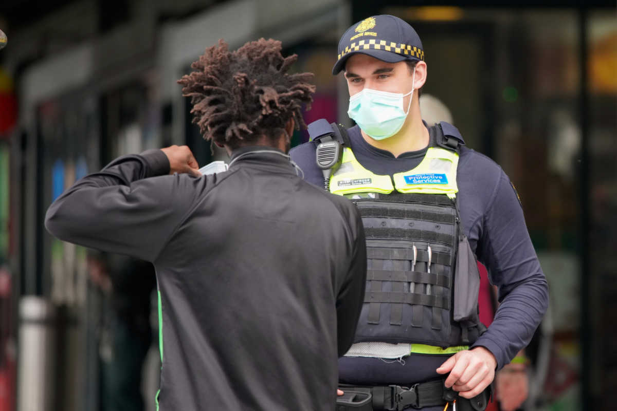 A Protective Services Officer wearing a face mask talks to a member of public in Melbourne after it became the first city in Australia to enforce mask-wearing in public as part of efforts to curb a resurgence of the coronavirus disease (COVID-19), July 23, 2020. REUTERS