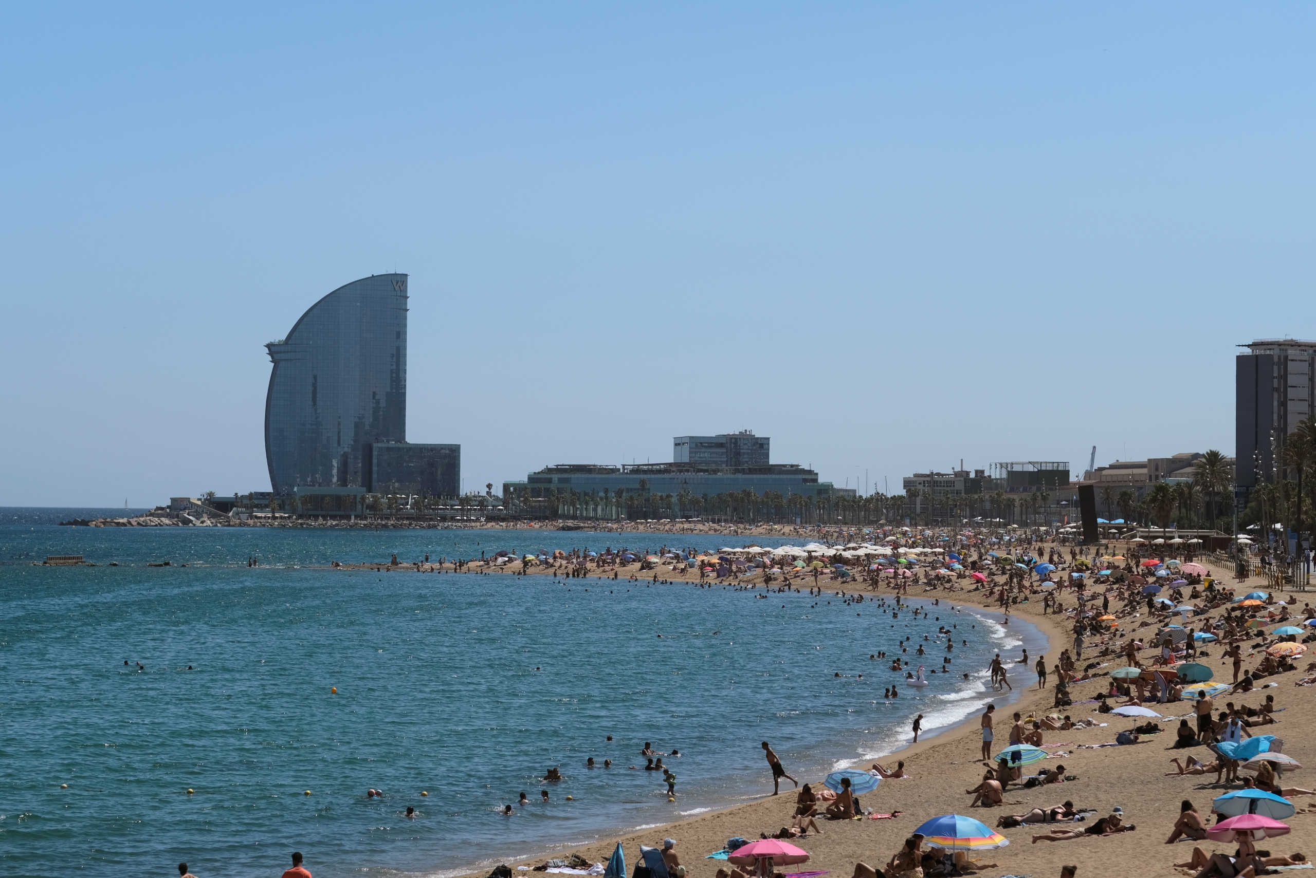 People enjoy the beach, after Catalonia's regional authorities and the city council announced restrictions to contain the spread of the coronavirus disease (COVID-19) in Barcelona, Spain July 19, 2020. REUTERS