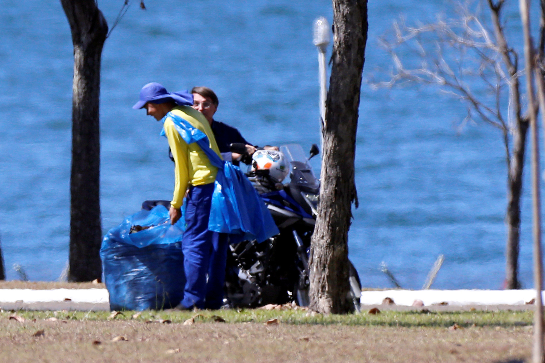 Brazil's President Jair Bolsonaro talks to workers during a motorcycle ride at the Alvorada Palace, amid the coronavirus disease (COVID-19) outbreak, in Brasilia, Brazil, July 23, 2020. REUTERS