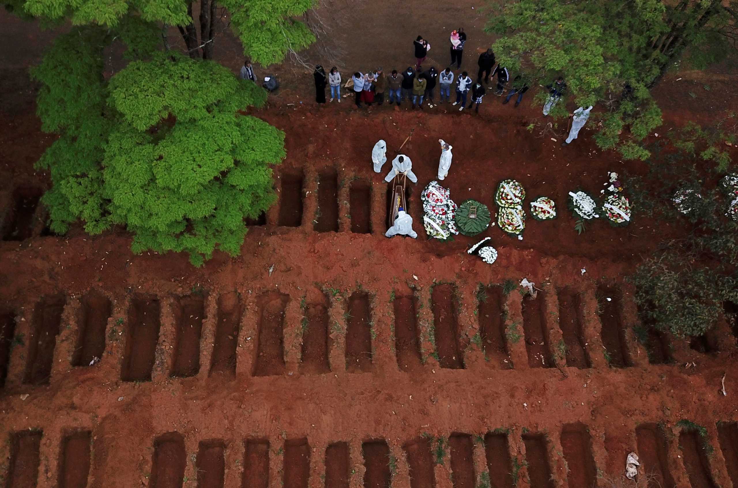 Gravediggers wearing protective suits bury a coffin at Vila Formosa cemetery during the outbreak of the coronavirus disease (COVID-19), in Sao Paulo, Brazil, July 16, 2020. Picture taken with a drone. REUTERS
