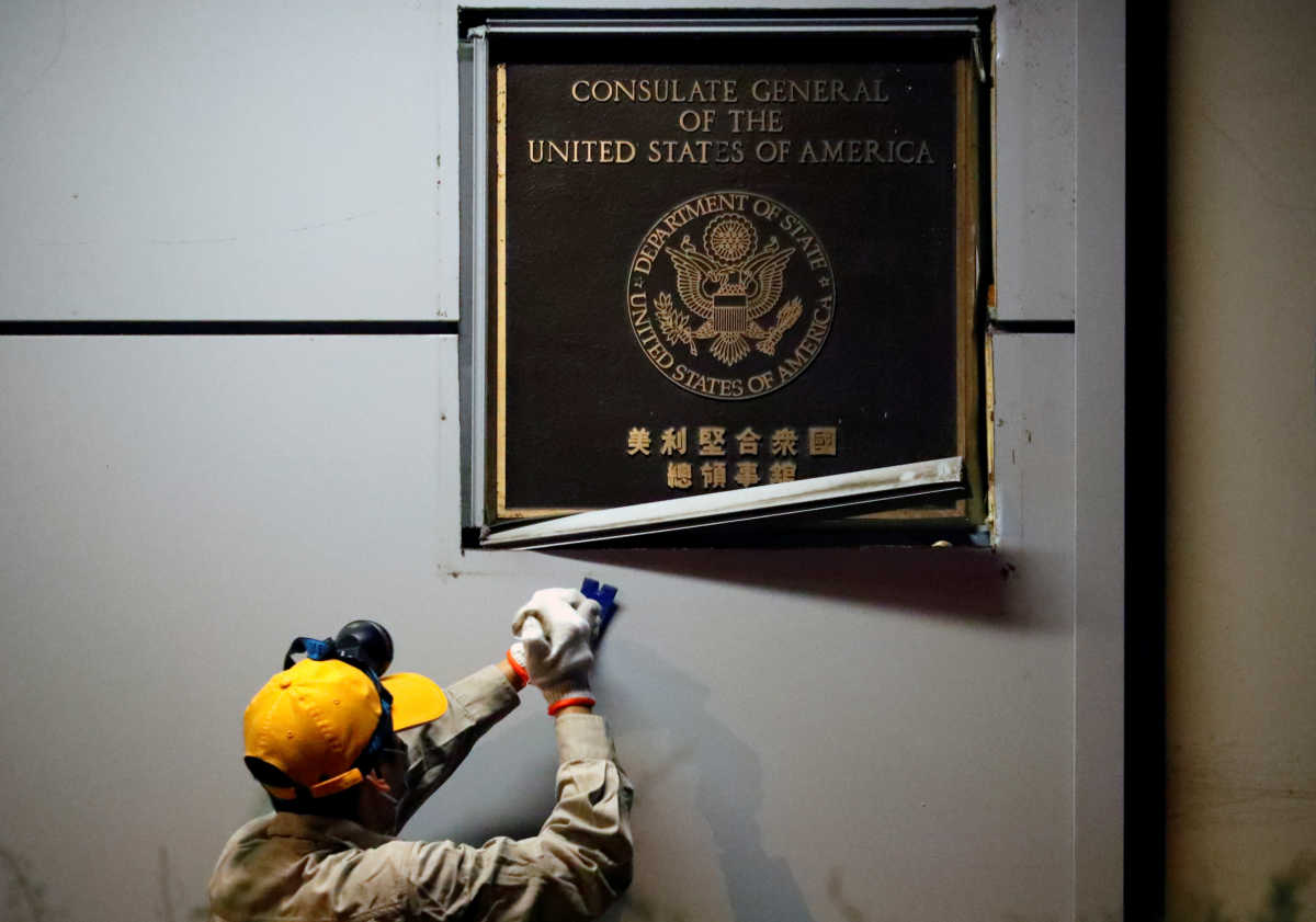A man works to remove the U.S. Consulate plaque at the U.S. Consulate General in Chengdu, Sichuan province, China, July 26, 2020. REUTERS