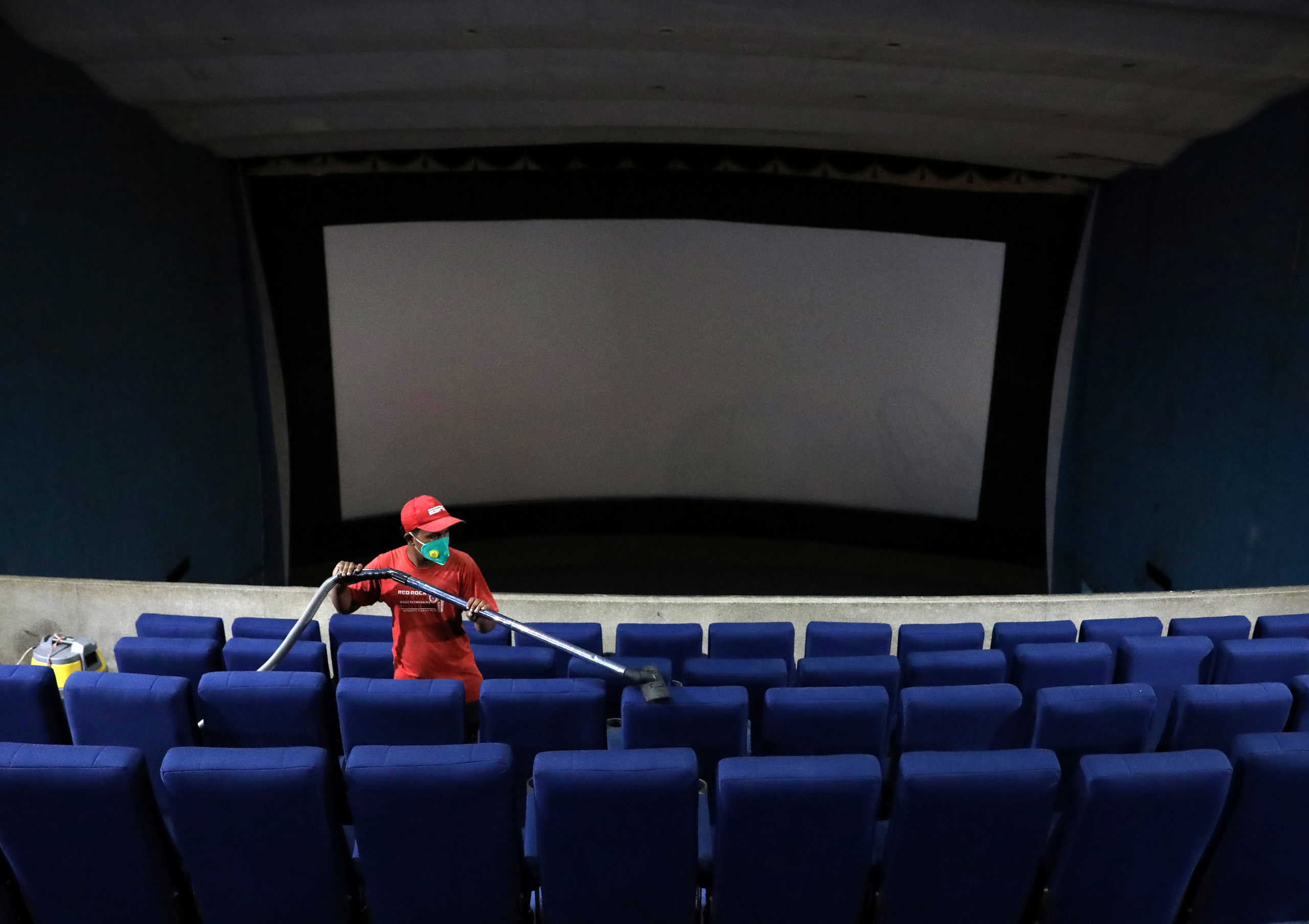 A worker cleans the seats during a routine cleaning of Navina cinema hall that was closed following the outbreak of the coronavirus disease (COVID-19), in Kolkata, India, July 16, 2020. REUTERS