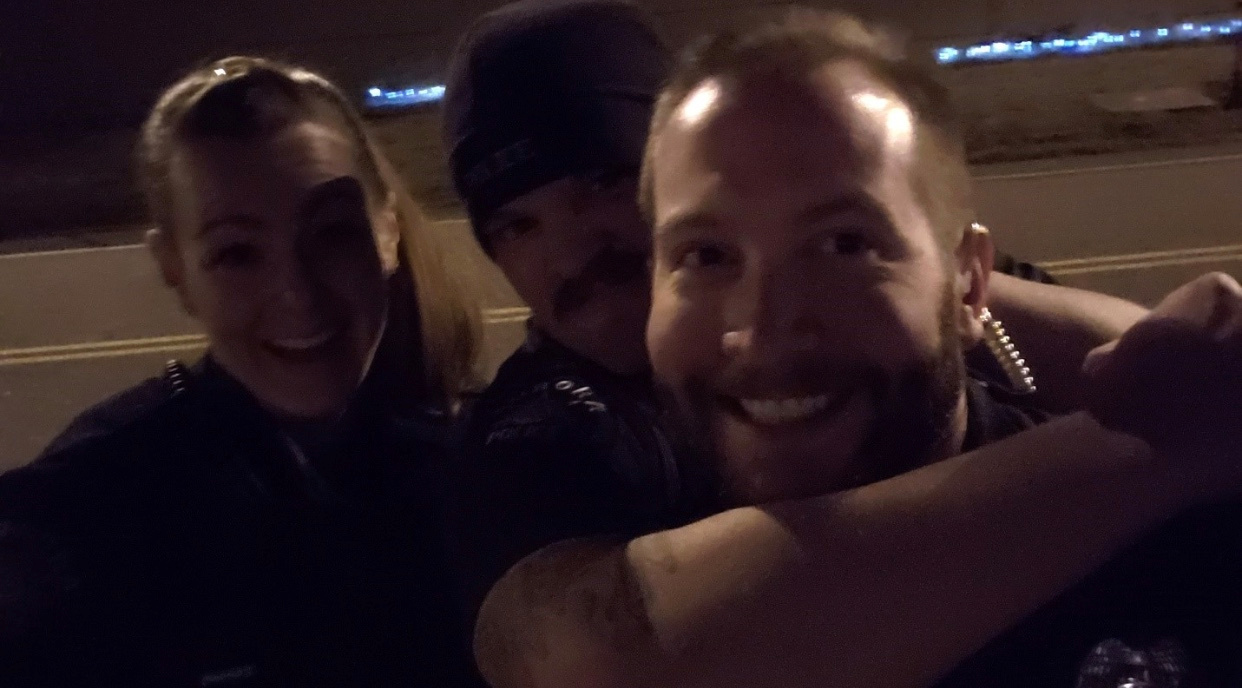 Aurora Police Department officers Erica Marrero, Jaron Jones and Kyle Dittrich reenact a chokehold near a memorial to Elijah McClain, in Aurora, Colorado, U.S. October 2019. Picture taken October 2019. Aurora Police Department