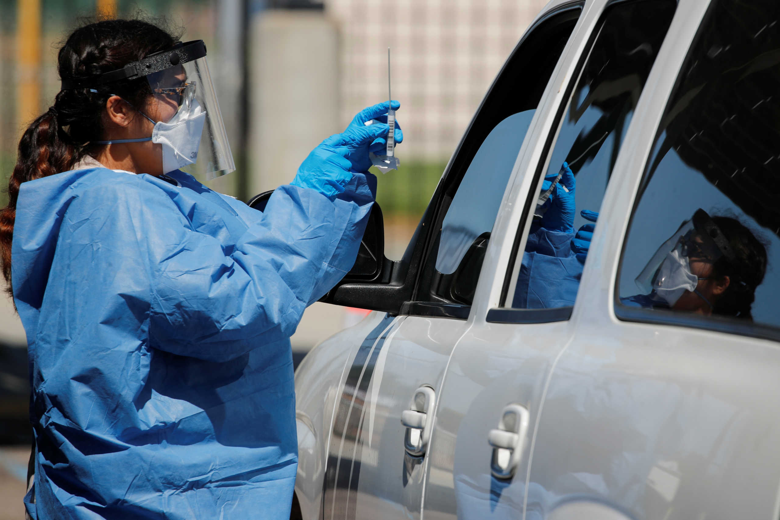 A San Diego county nurse works at a newly opened drive through testing site at a closed high school in Imperial Beach, California, U.S., July 16, 2020. REUTERS