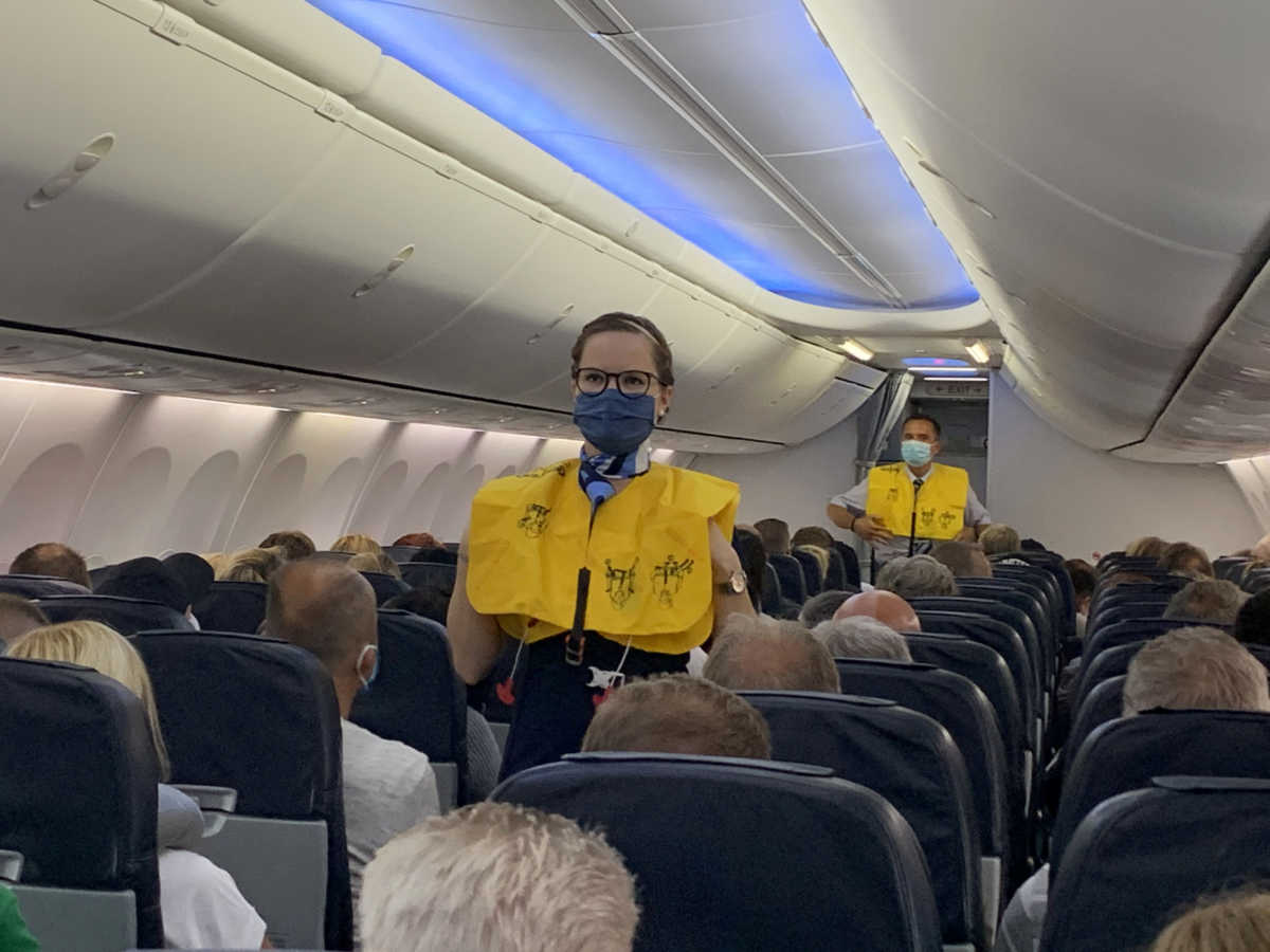 FILE PHOTO: Flight attendants of TUI Fly wear face masks as they give instructions to German tourists on the first flight from Duesseldorf to Mallorca, two weeks before Spain starts reopening borders closed since mid-March to curb the coronavirus disease (COVID-19) pandemic, in Duesseldorf, Germany, June 15, 2020. REUTERS