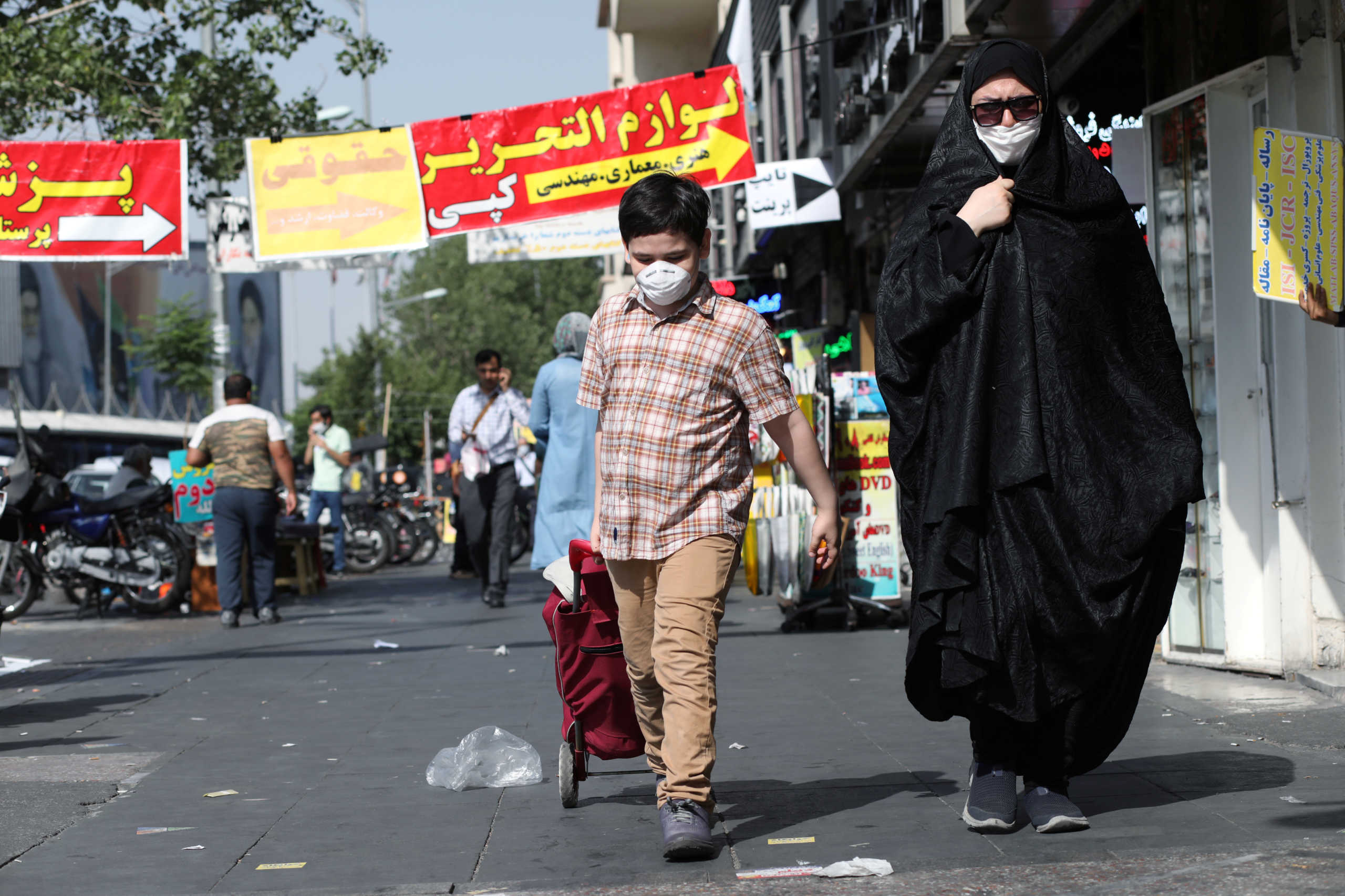 An Iranian woman and her son wearing a protective face mask walks the street, following the outbreak of the coronavirus disease (COVID-19), in Tehran, Iran, June 28, 2020. WANA (West Asia News Agency) via REUTERS ATTENTION EDITORS - THIS PICTURE WAS PROVIDED BY A THIRD PARTY