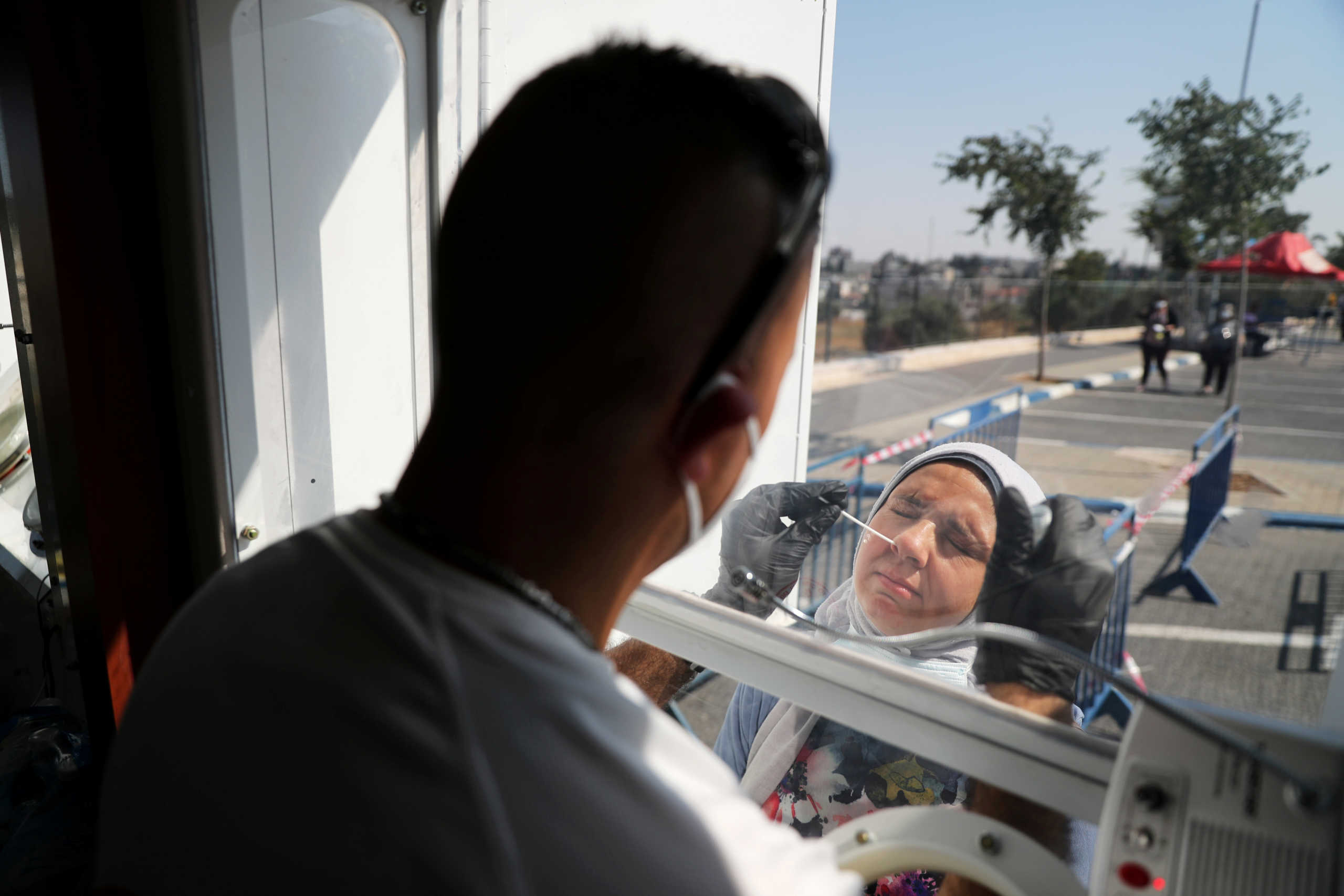 A Palestinian woman gets tested for the coronavirus disease (COVID-19) in East Jerusalem July 6, 2020. REUTERS