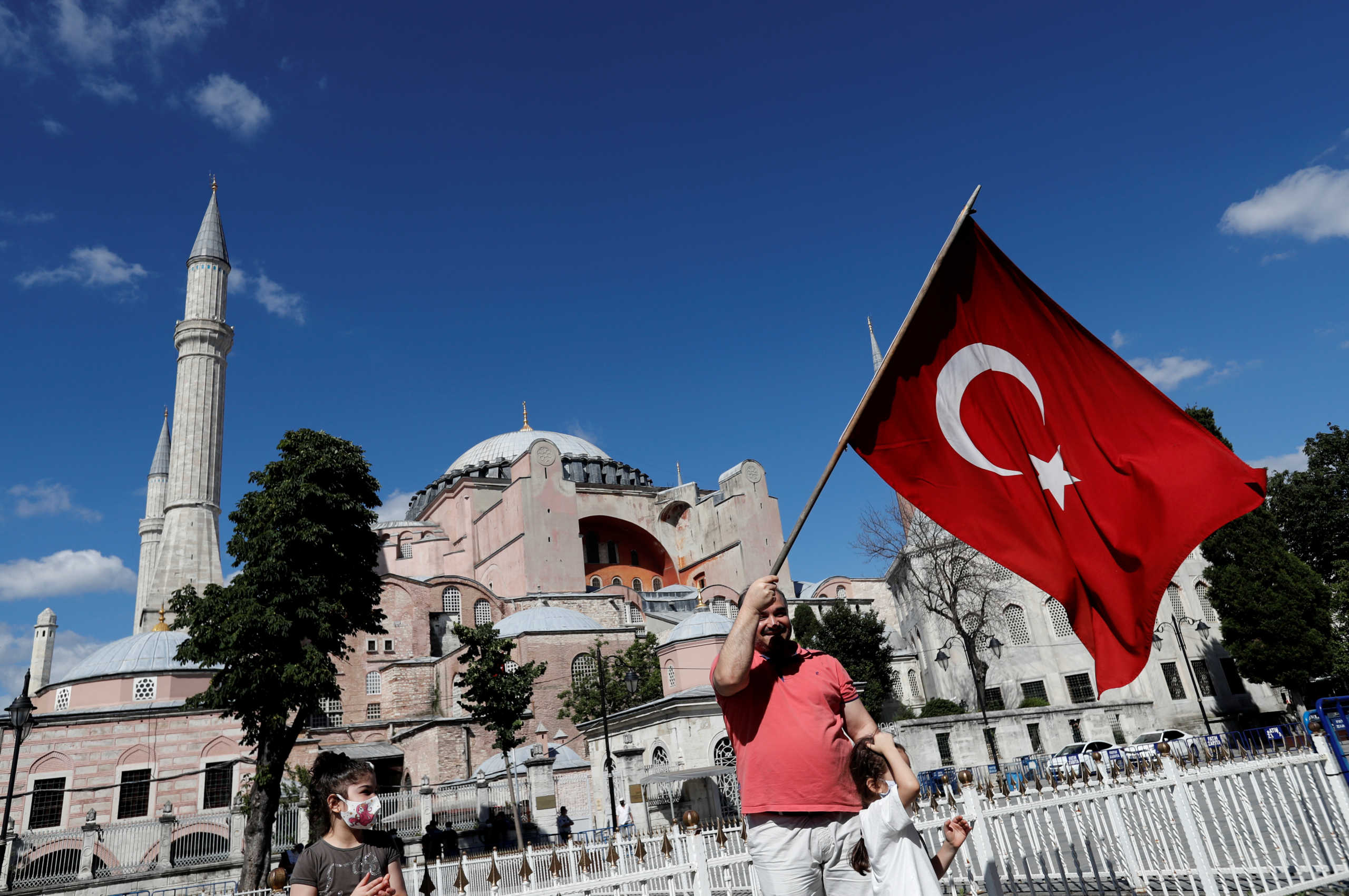 A man waves a Turkish Flag in front of the Hagia Sophia or Ayasofya, after a court decision that paves the way for it to be converted from a museum back into a mosque, in Istanbul, Turkey, July 10, 2020. REUTERS