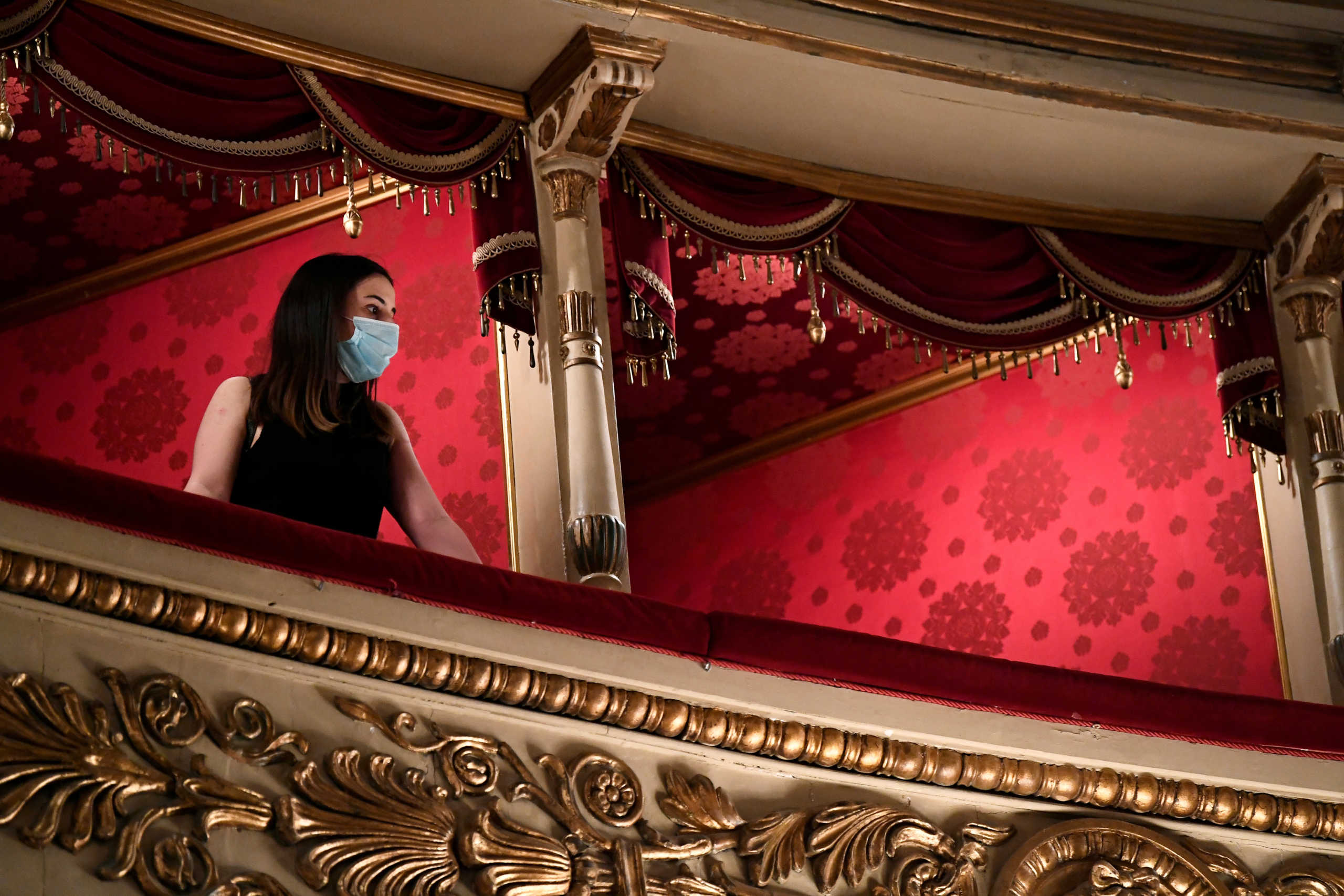 FILE PHOTO: A visitor wearing a face mask looks on as Italy's La Scala opera house reopens to the public for the first time since the coronavirus disease (COVID-19) outbreak, with new social distancing and hygiene rules, in Milan, Italy, June 21, 2020. REUTERS