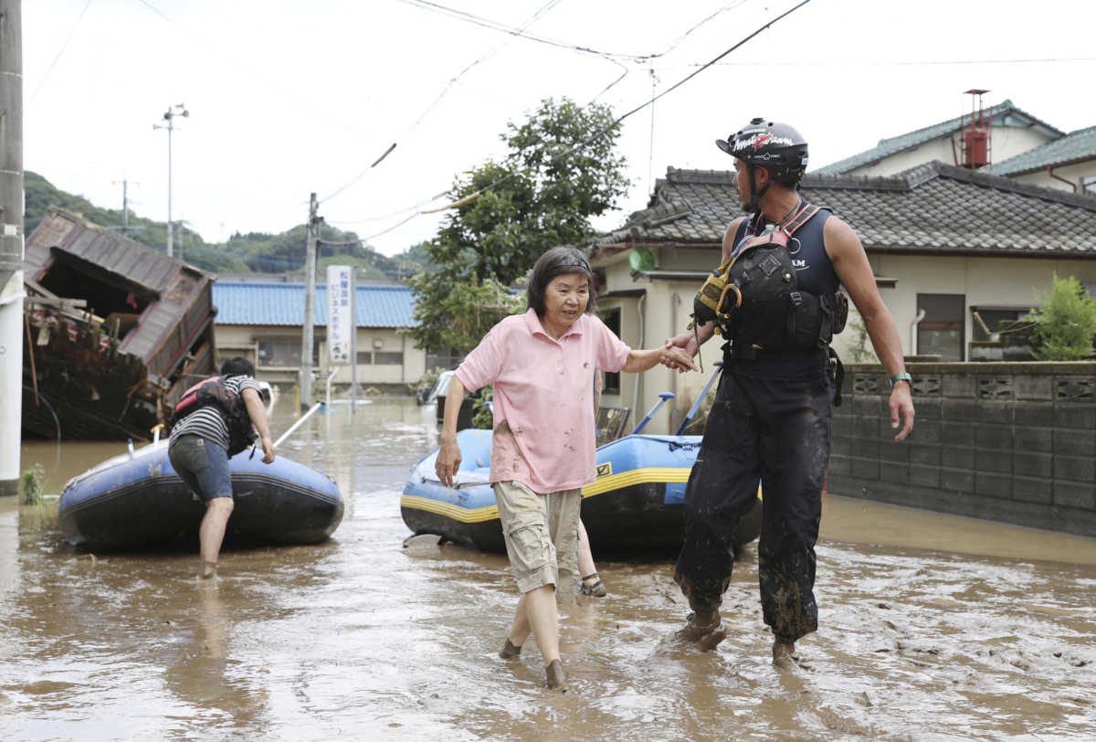 A rescue worker helps local residents at a flooded area caused by a heavy rain along Kuma River in Hitoyoshi, Kumamoto prefecture, southern Japan, in this photo taken by Kyodo July 4, 2020. Mandatory credit Kyodo