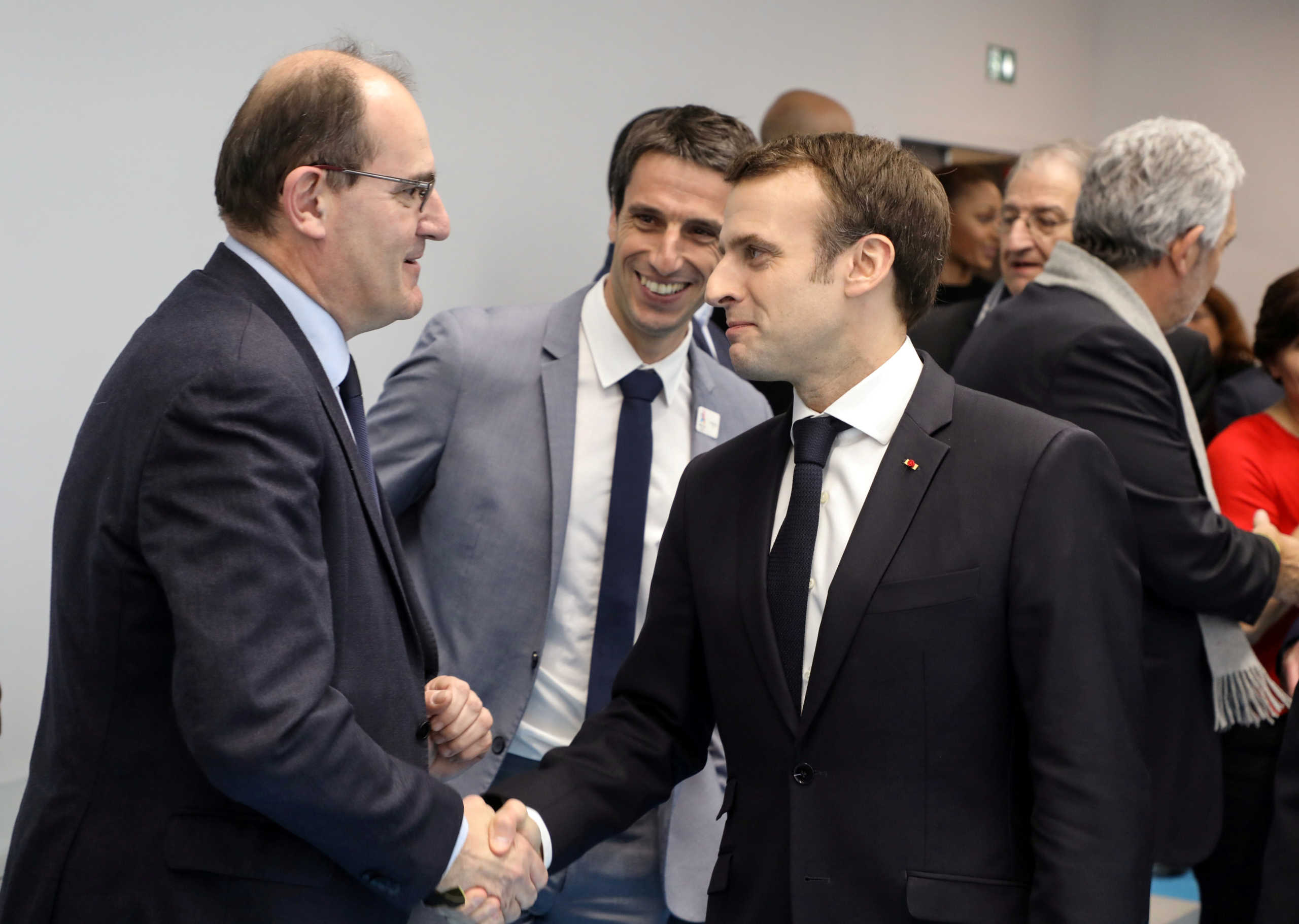 FILE PHOTO: French President Emmanuel Macron shakes hands with Interministerial Delegate for the Olympic and Paralympic Games 2024 Jean Castex (L) flanked by President of the Paris Organising Committee of the 2024 Olympic and Paralympic Games Tony Estanguet during the inauguration of a new handball complex in Creteil, on the outskirts of Paris, France January 9, 2019. Ludovic Marin