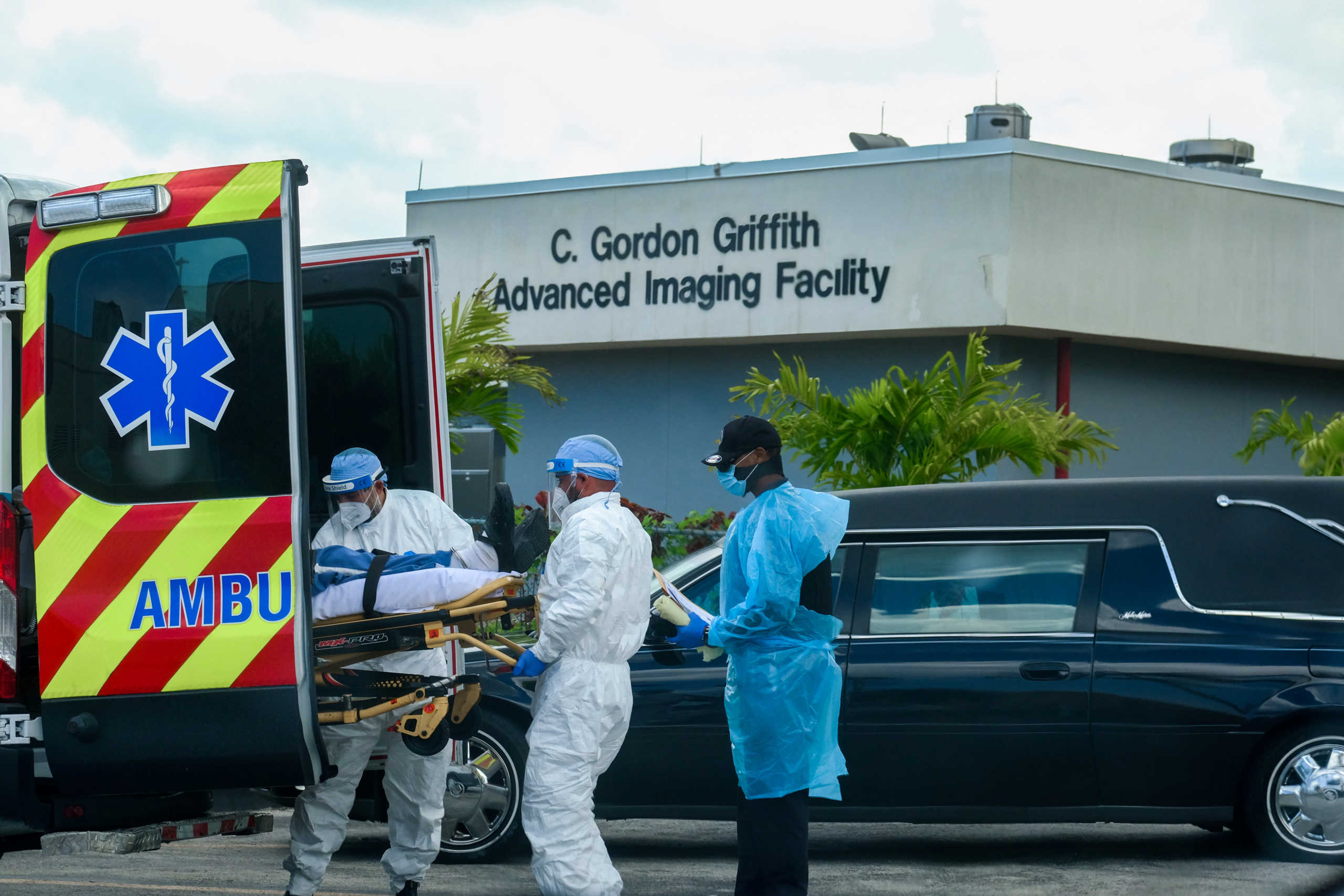 Emergency Medical Technicians (EMT) arrive with a patient while a funeral car begins to depart at North Shore Medical Center where the coronavirus disease (COVID-19) patients are treated, in Miami, Florida, U.S. July 14, 2020. REUTERS