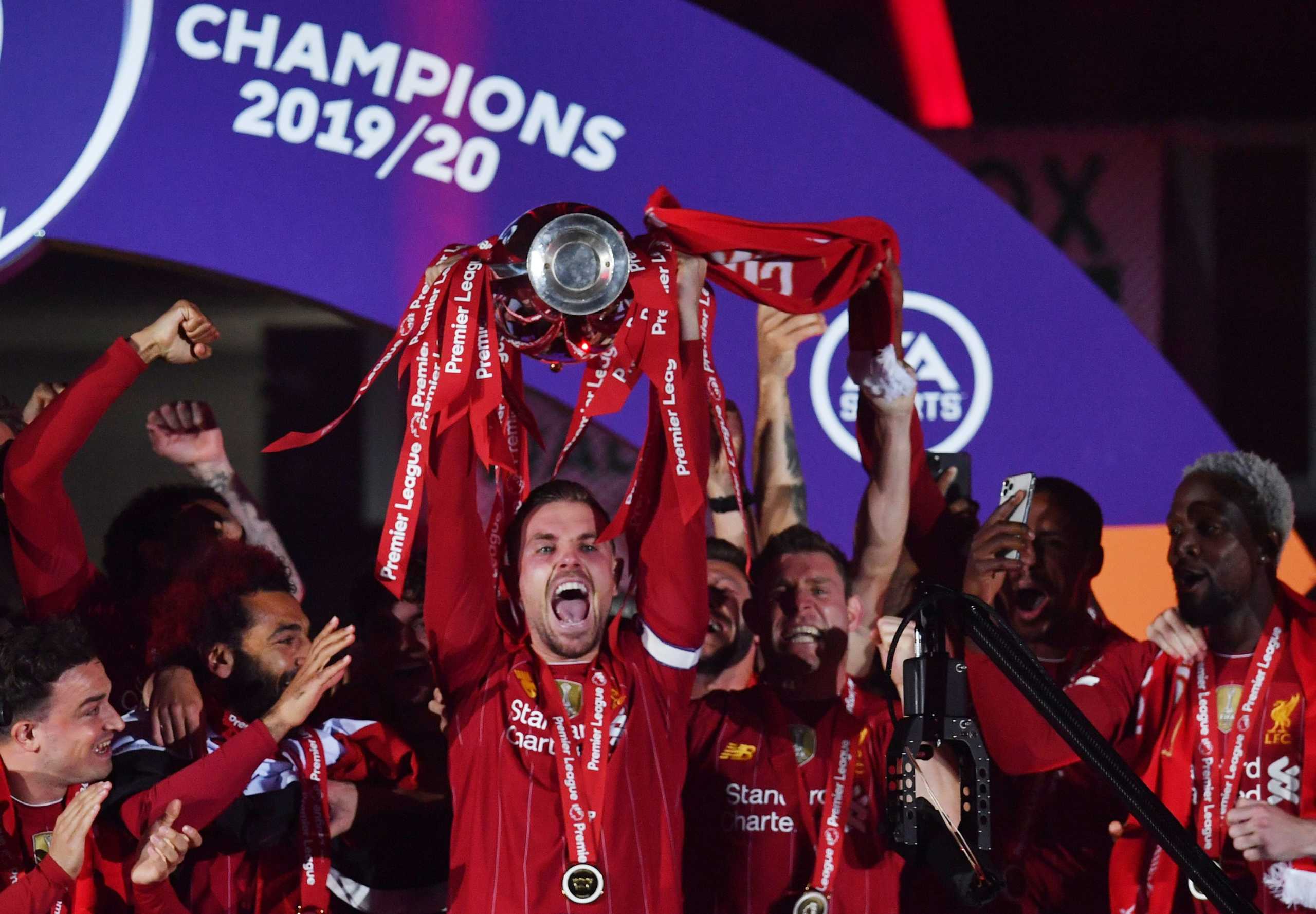 Soccer Football - Premier League - Liverpool v Chelsea - Anfield, Liverpool, Britain - July 22, 2020 Liverpool's Jordan Henderson with teammates celebrates with the trophy after winning the Premier League Pool via REUTERS