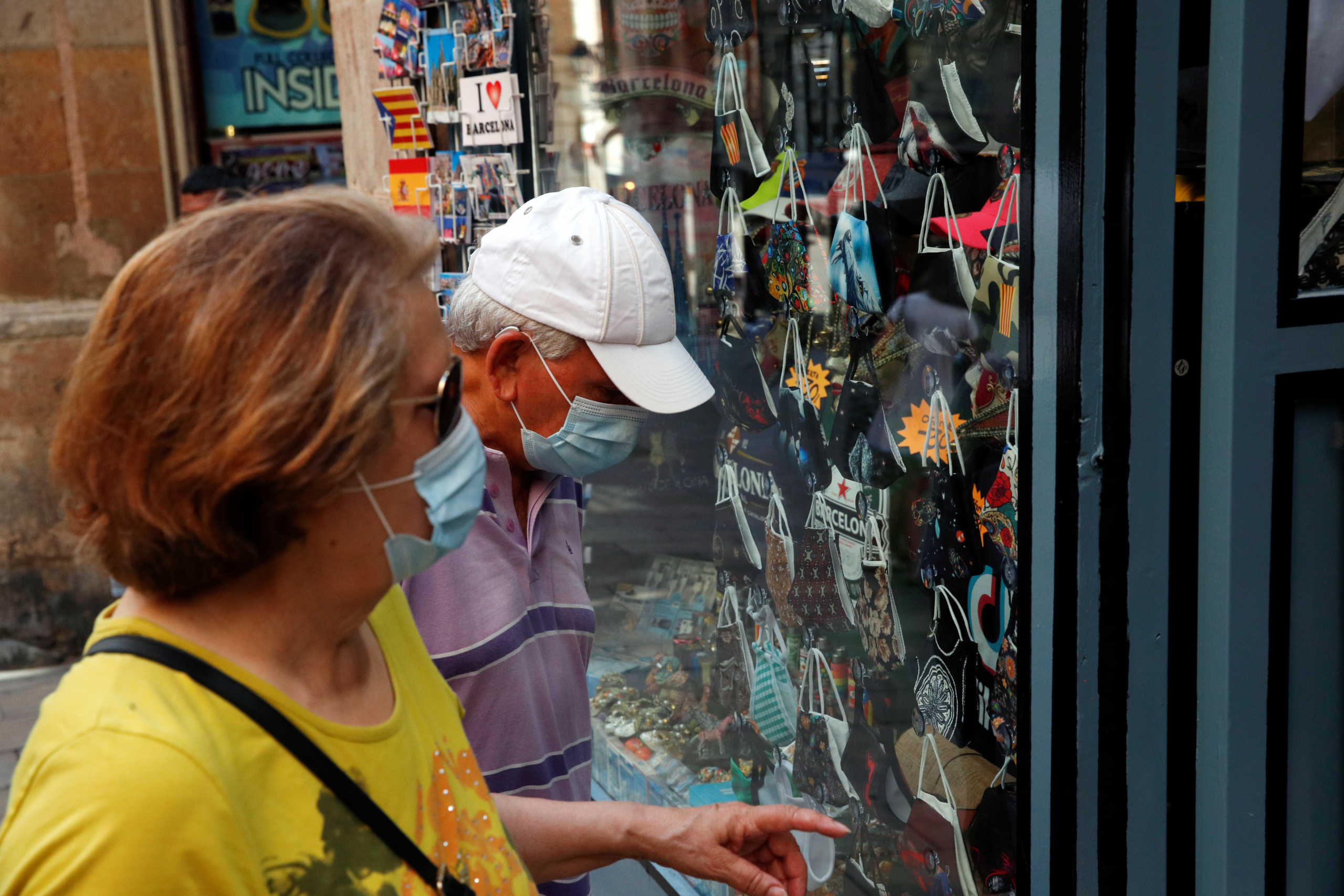People look at masks displayed at a souvenir shop, amid the coronavirus disease (COVID-19) outbreak, in Barcelona, Spain July 27, 2020. REUTERS