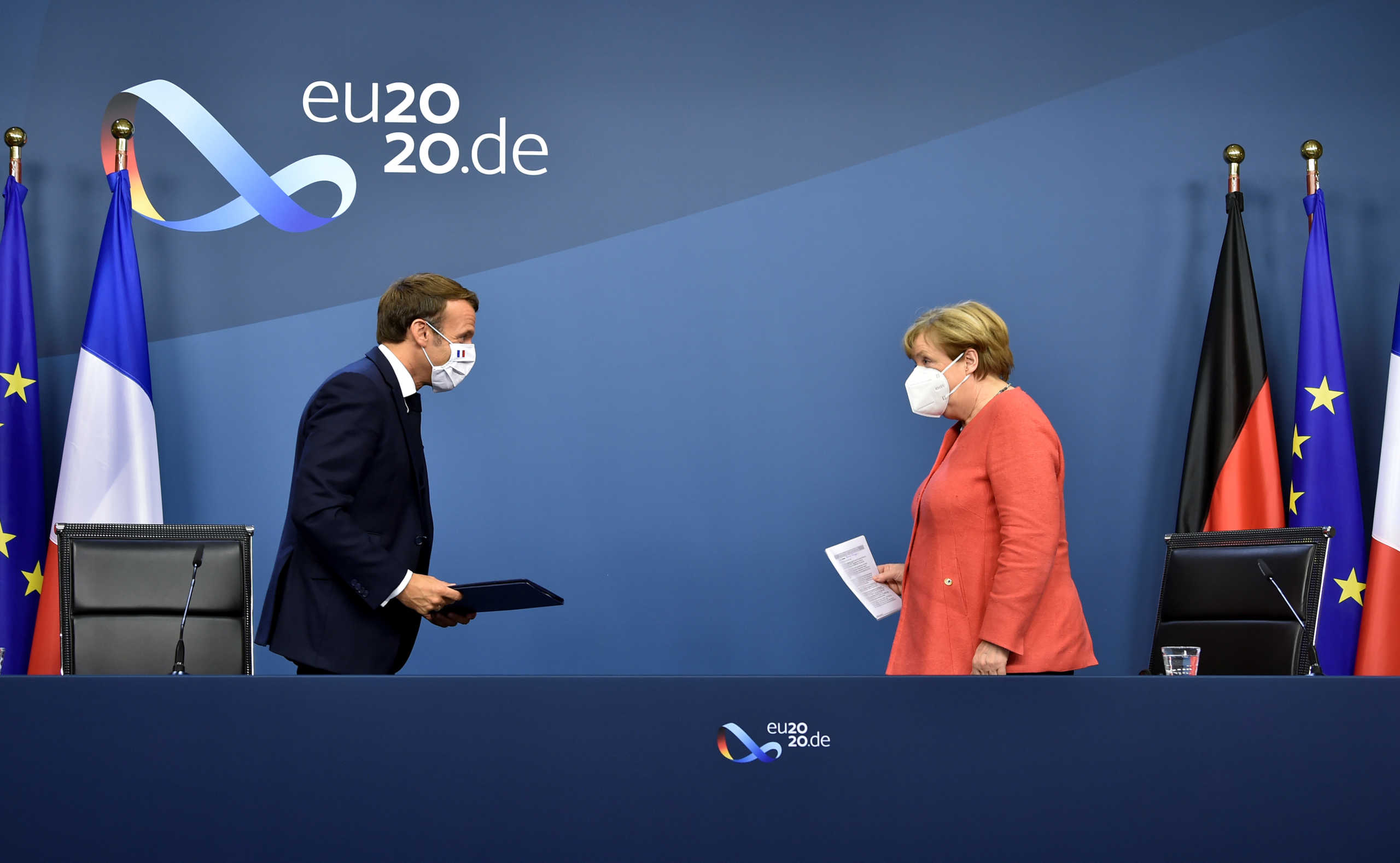 German Chancellor Angela Merkel and French President Emmanuel Macron leave after their joint video press conference at the end of the European summit at the EU headquarters in Brussels, Belgium July 21, 2020. John Thys