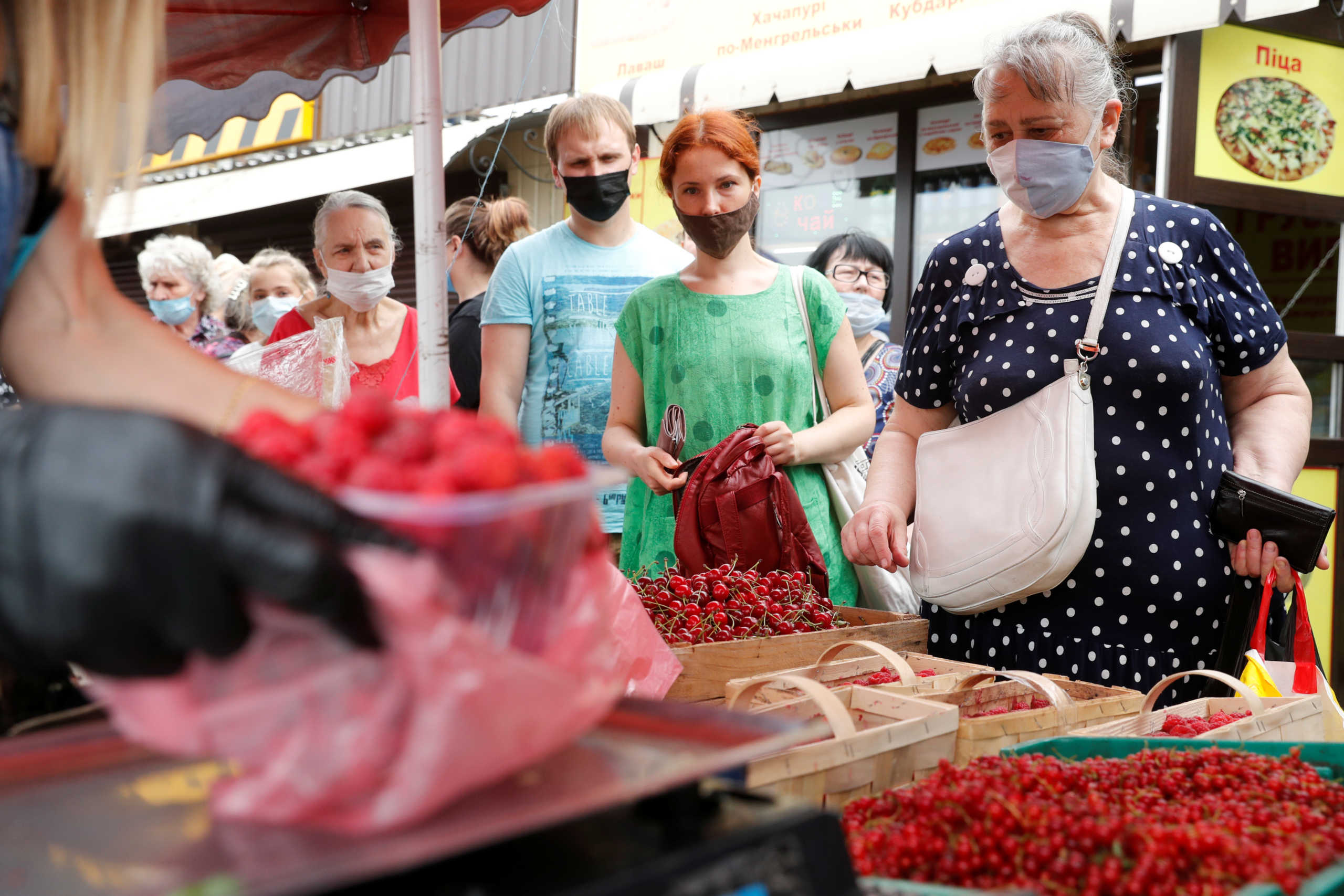 People wearing protective face masks stay in queue to buy fruits at a market, amid the outbreak of the coronavirus disease (COVID-19) in Kyiv, Ukraine July 7, 2020.  REUTERS