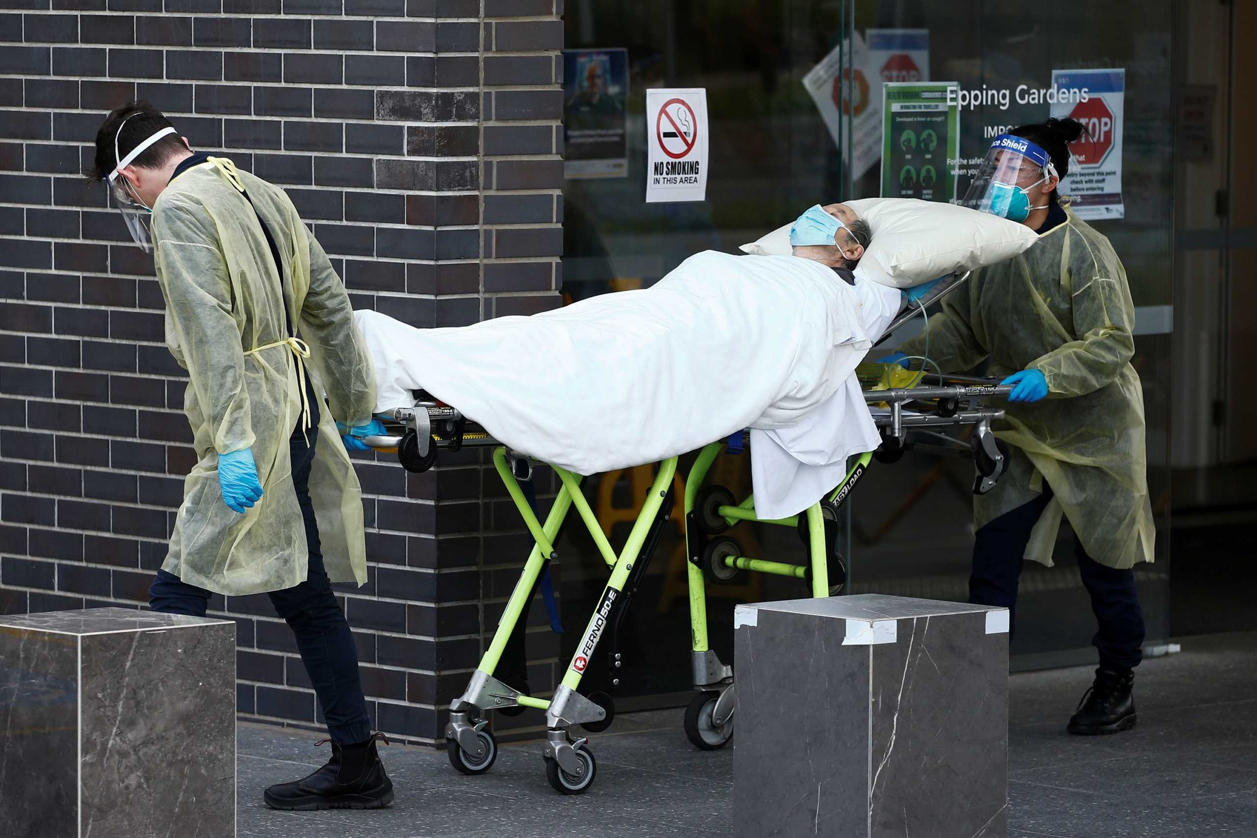 A resident is taken to an ambulance from an aged care facility experiencing an outbreak of the coronavirus disease (COVID-19) in Melbourne, Australia, July 28, 2020.  AAP Image