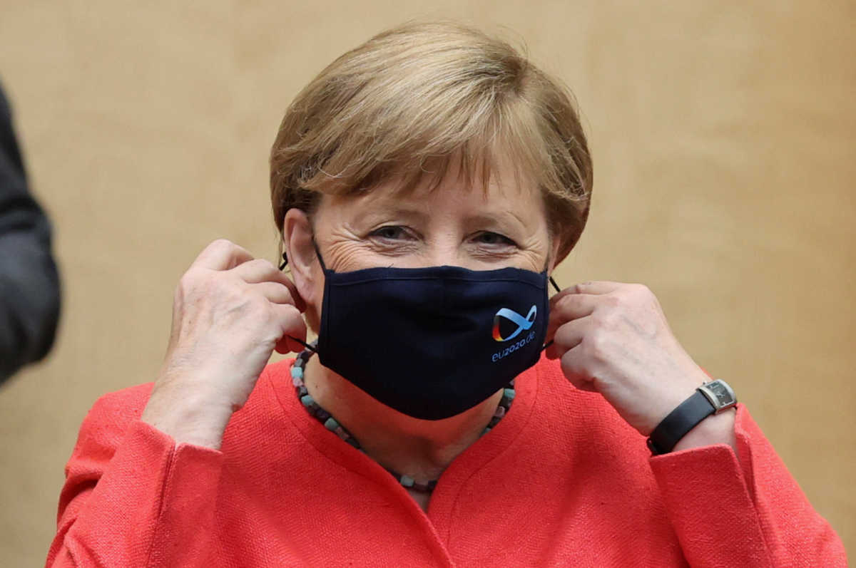 German Chancellor Angela Merkel takes off her face mask during a session at the upper house of the German parliament Bundesrat, following the outbreak of the coronavirus disease (COVID-19), in Berlin, Germany, July 3, 2020. REUTERS