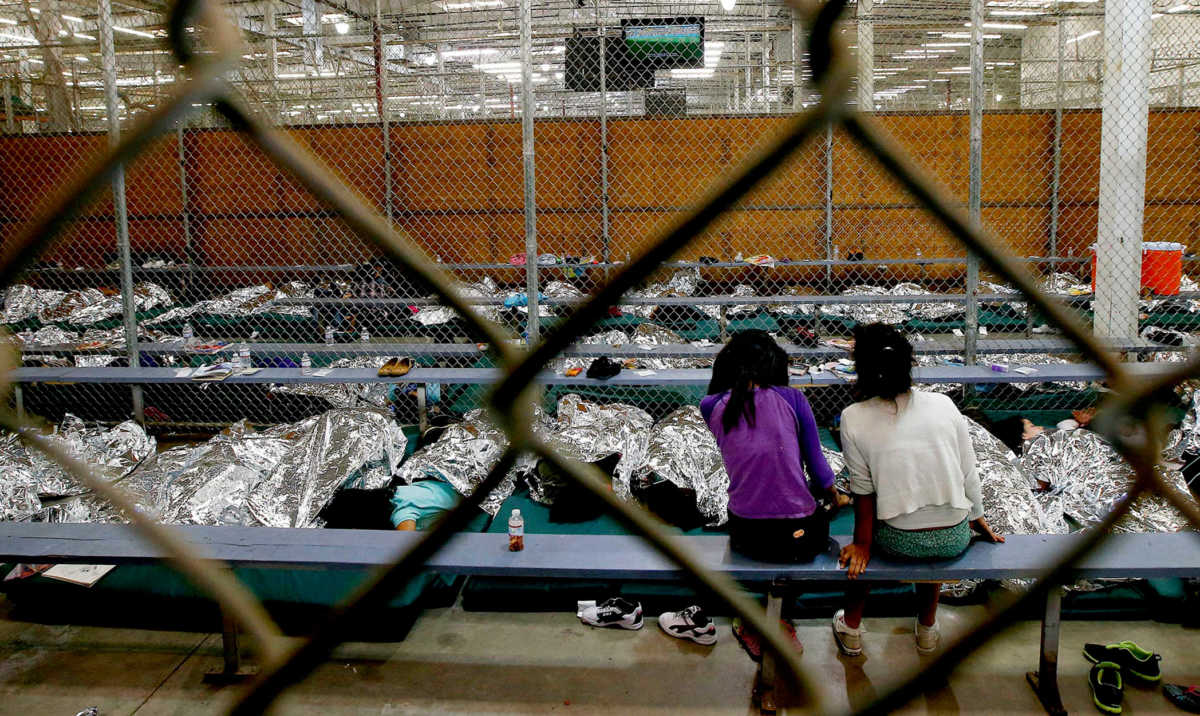FILE PHOTO:    Two young girls watch a World Cup soccer match on a television from their holding area where hundreds of mostly Central American immigrant children are being processed and held at the U.S. Customs and Border Protection Nogales Placement Center in Nogales, Arizona June 18, 2014.       To match Special Report USA-IMMIGRATION