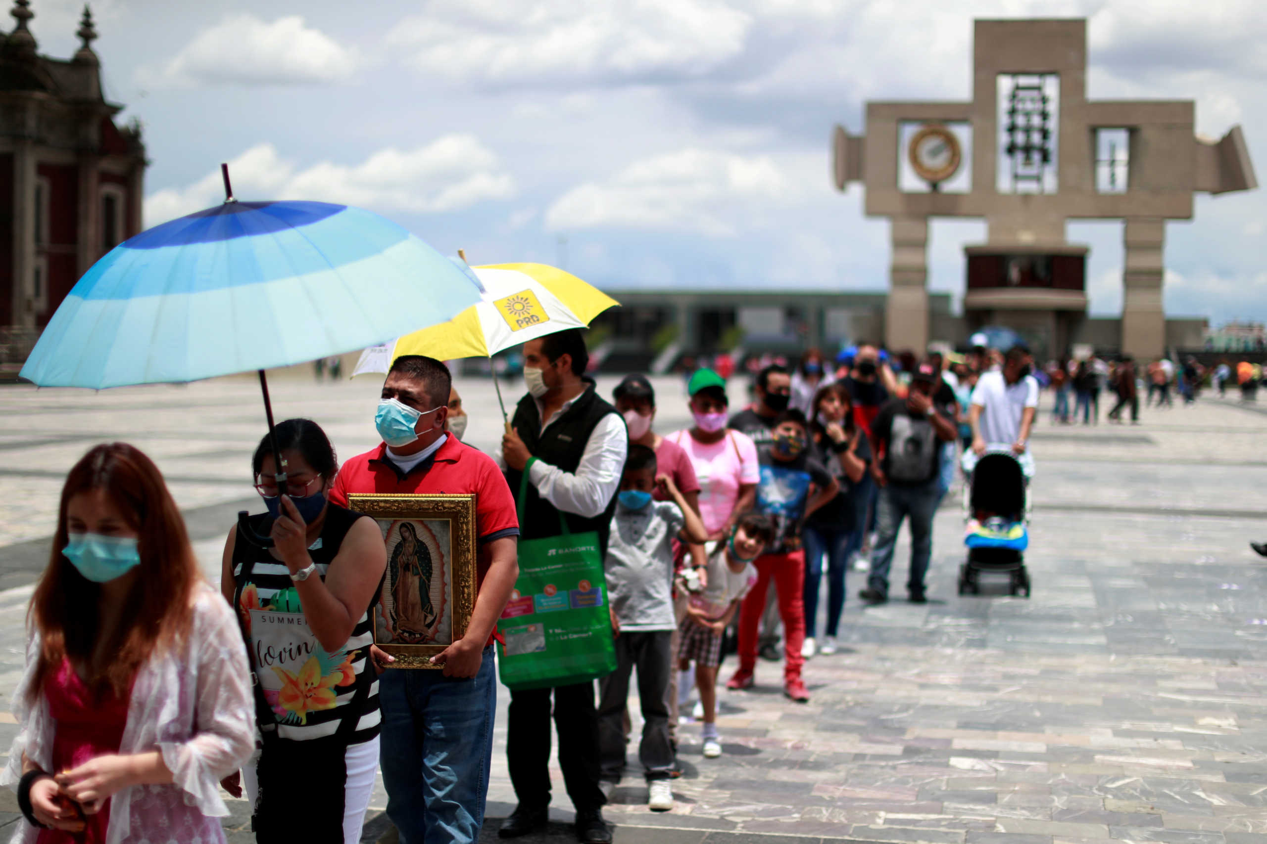 People wearing protective face masks queue to attend a mass on the first day of the reopening of the Basilica of Guadalupe after government restrictions were eased, amid the coronavirus disease (COVID-19) outbreak in Mexico City, Mexico July 26, 2020. REUTERS