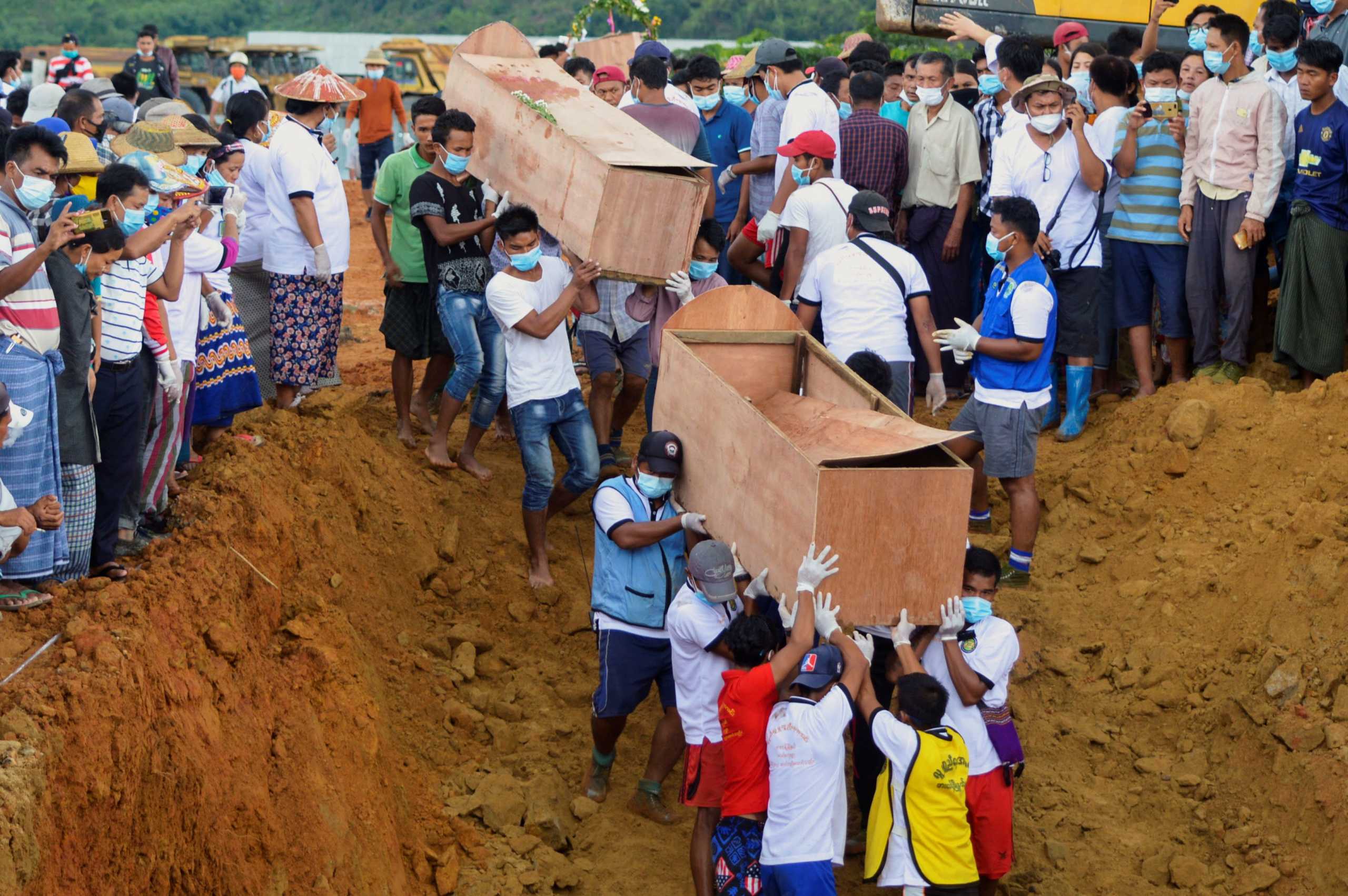 Volunteers carry coffins containing bodies of victims following a landslide at a mining site in Hpakant, Kachin State City, Myanmar July 3, 2020. REUTERS